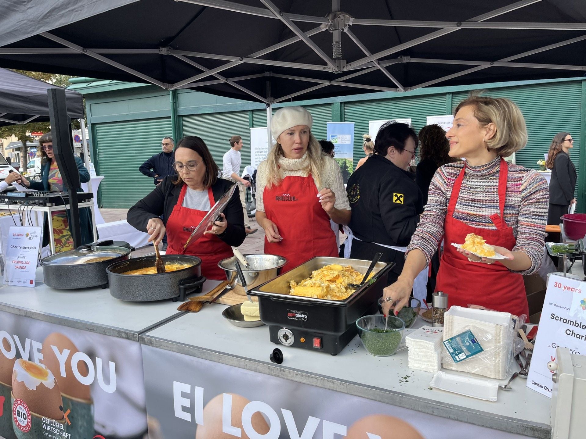 Drei Frauen bereiten bei einer Charity-Eierspeis am Naschmarkt Rührei an einem Stand zu.