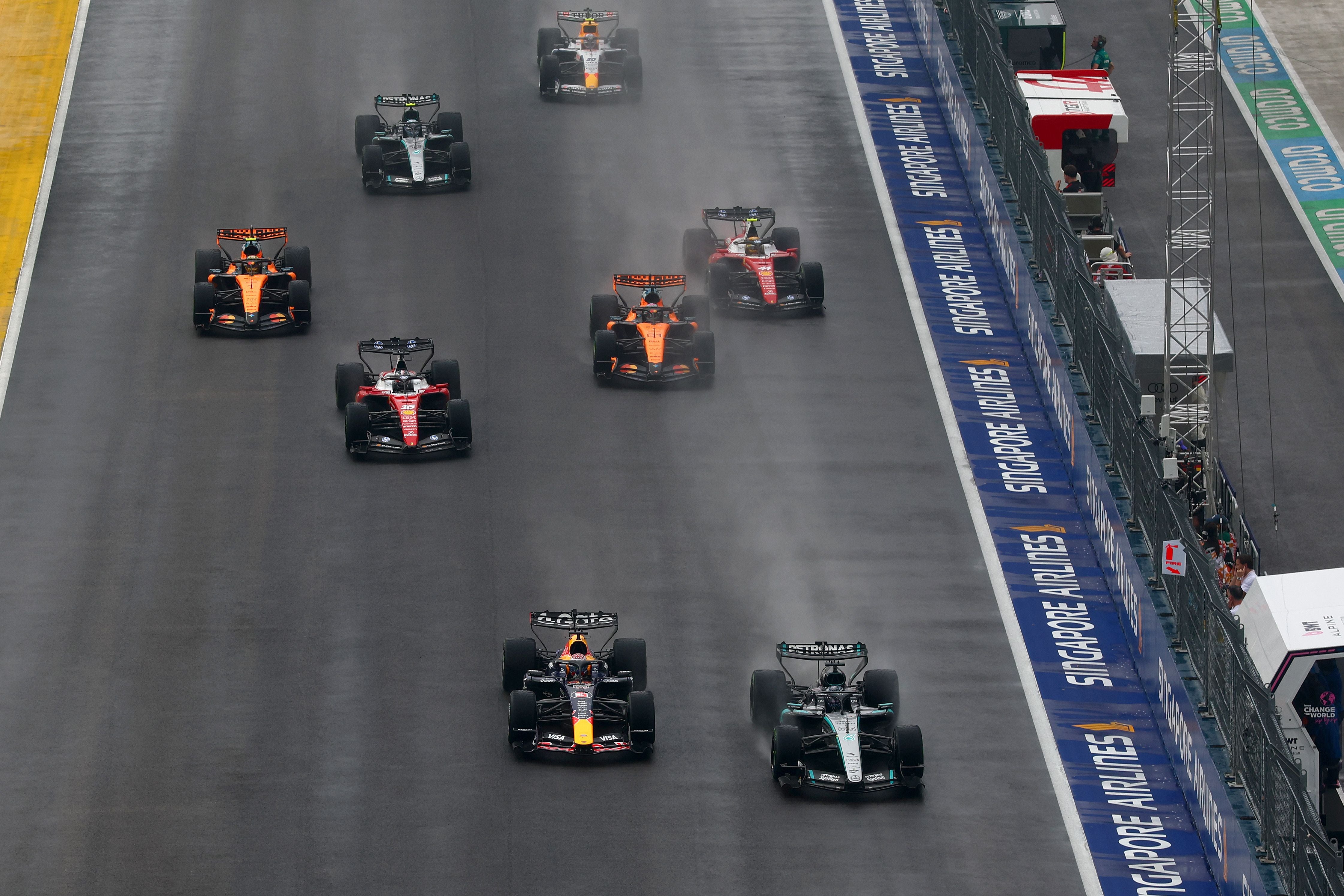 Formel-1-Autos fahren beim Start im Regen auf der Strecke des Marina Bay Circuit in Singapur.