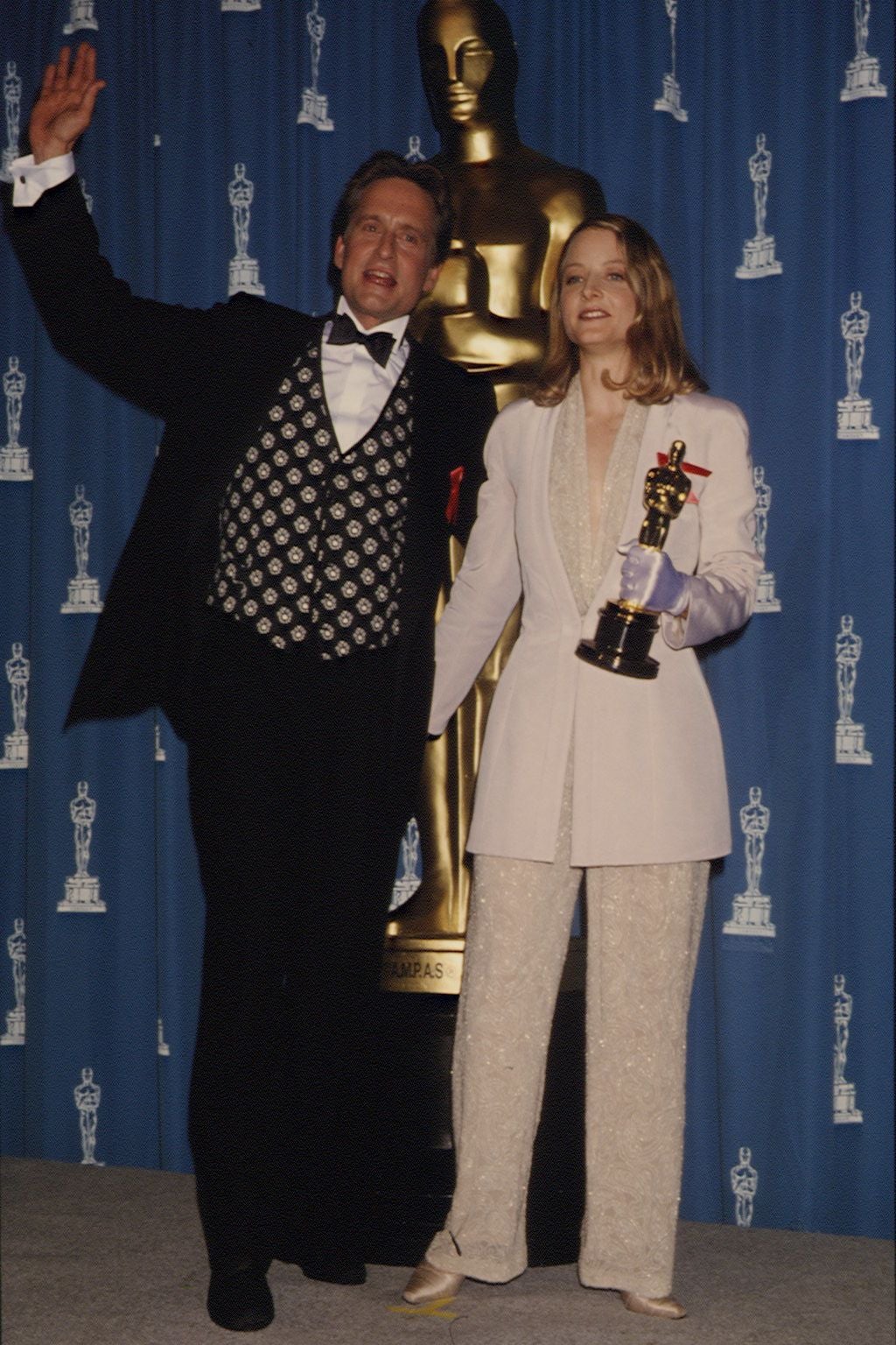 Zwei Personen posieren mit einem Oscar vor einer Statue bei den 64. Academy Awards.