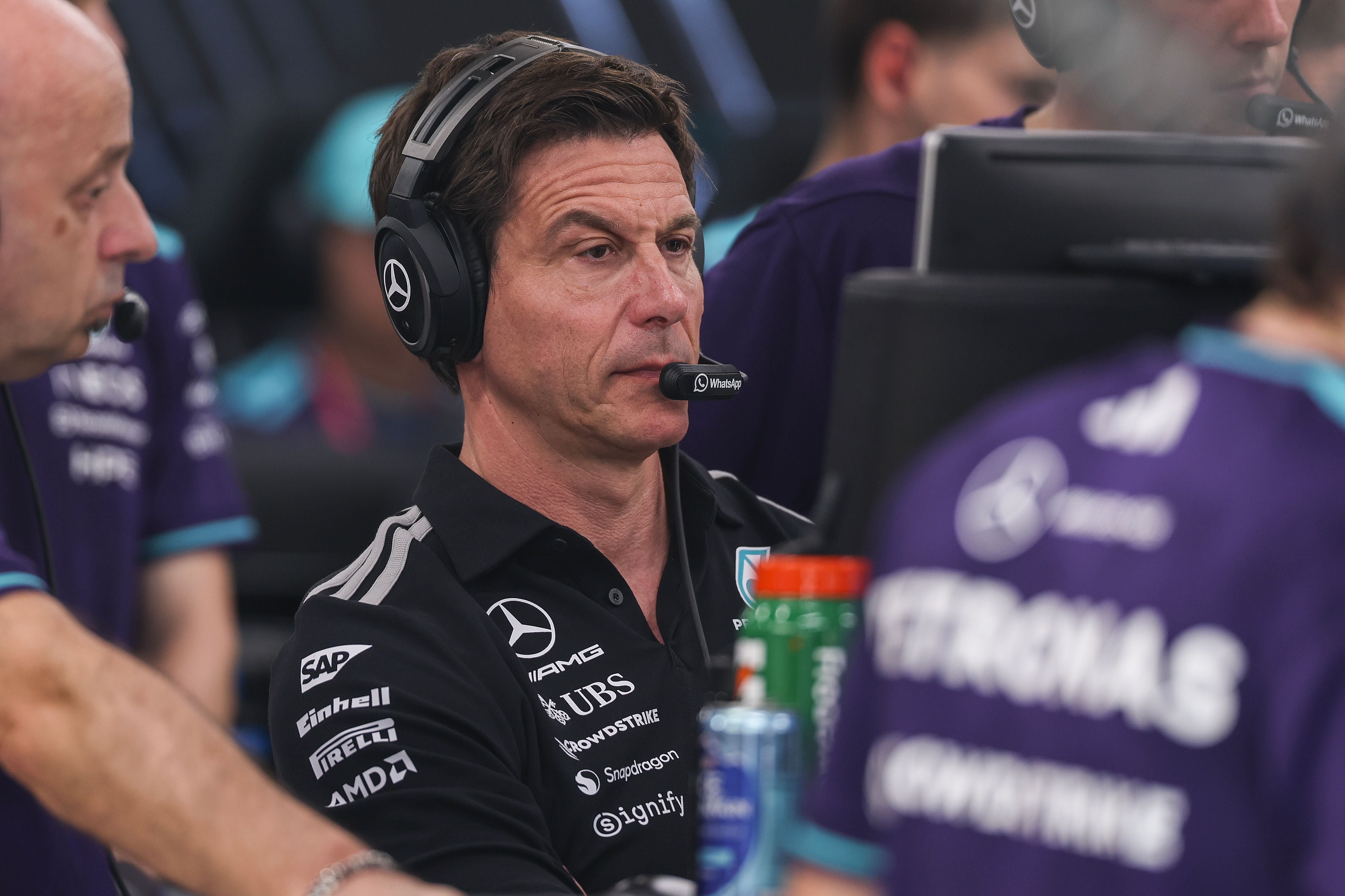 Mercedes-Teamchef Toto Wolff trägt ein Headset und verfolgt angespannt eine Rennsitzung am Monitor.