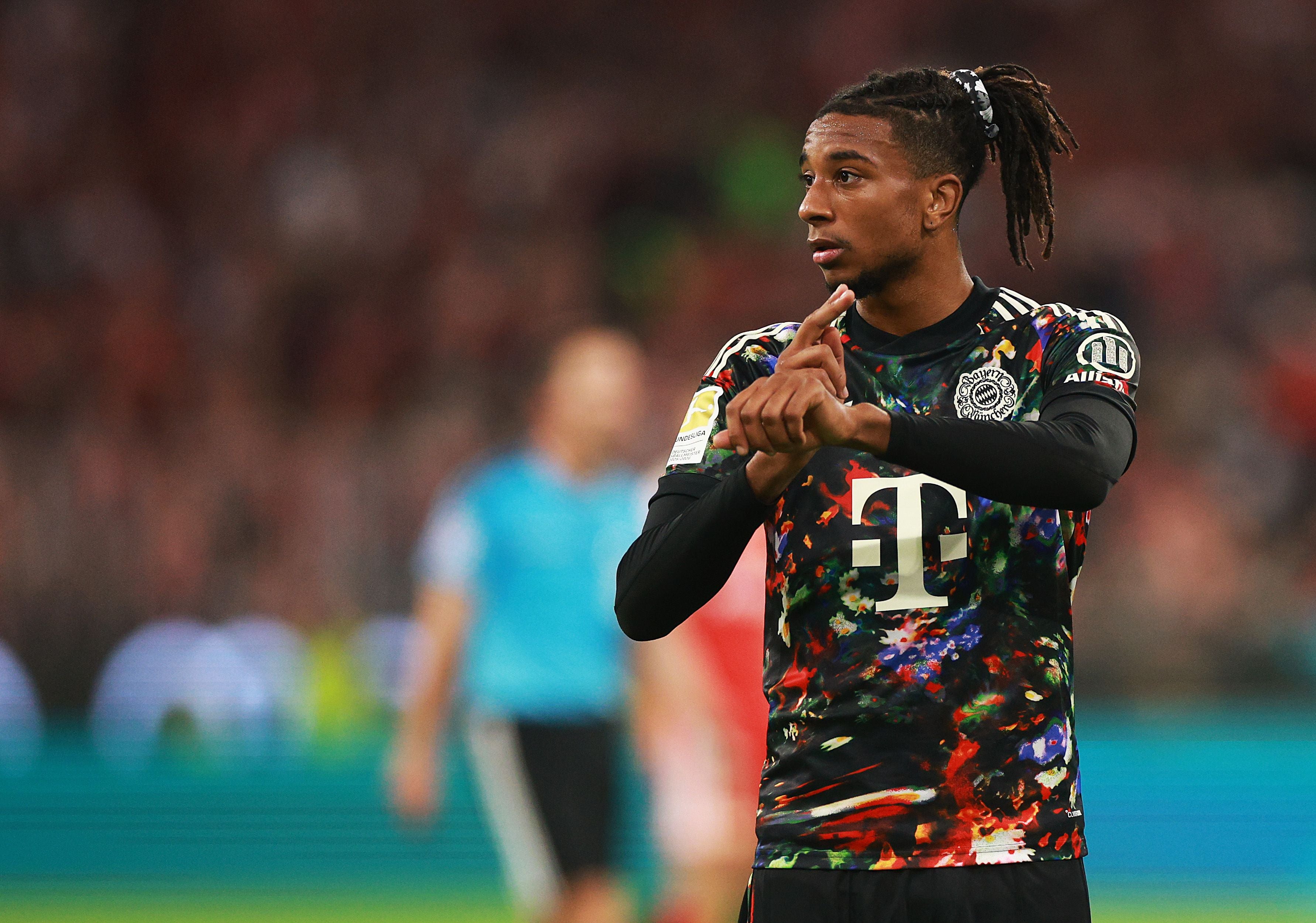 Ein Bayern-Spieler mit buntem Trikot gestikuliert auf dem Spielfeld während eines Spiels.
