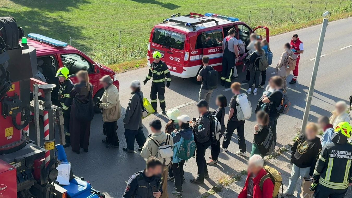 Feuerwehr und Einsatzkräfte evakuieren Menschen aus einem Zug auf offener Straße bei Baden.