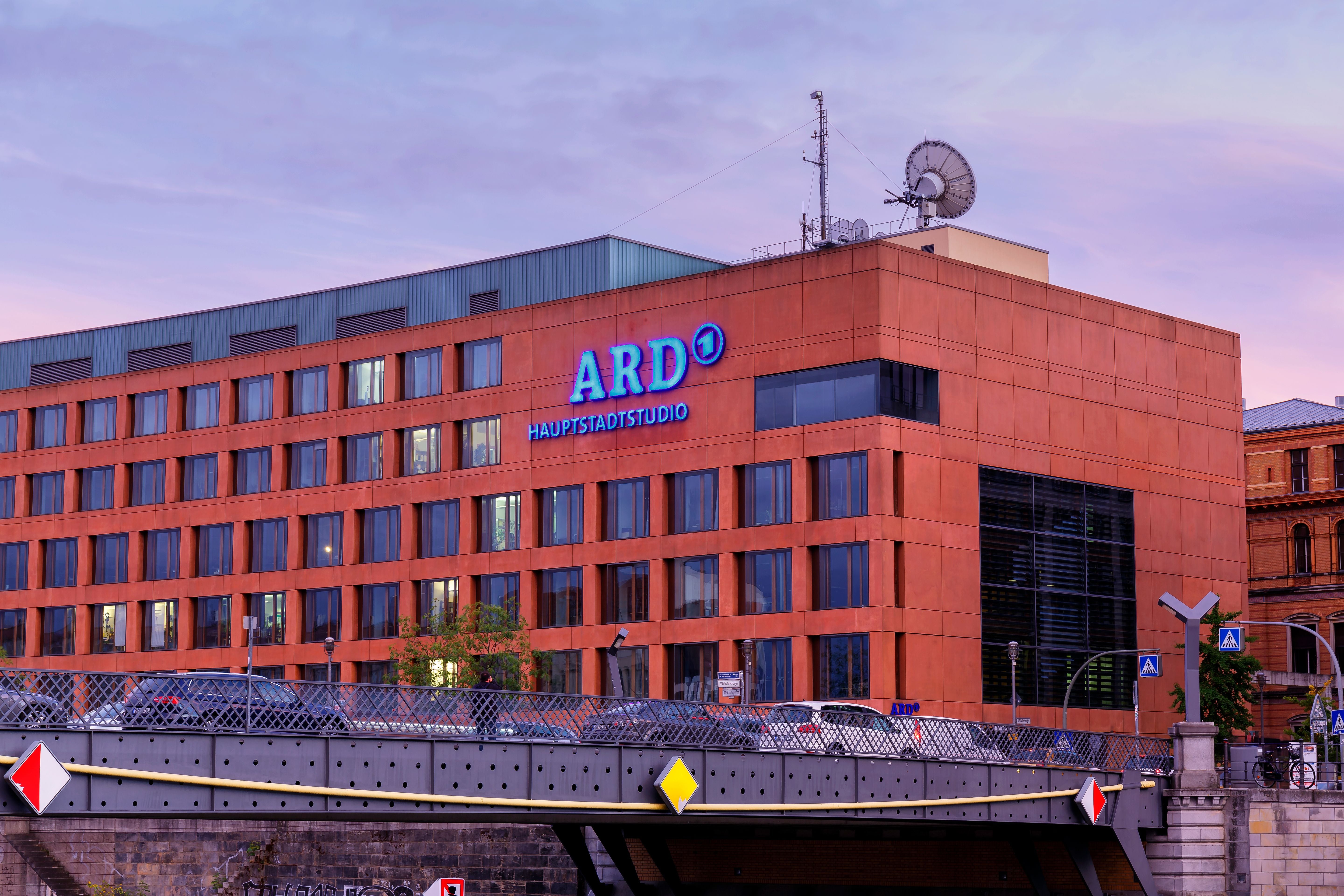 Das ARD-Hauptstadtstudio in Berlin bei Abenddämmerung mit Satellitenschüssel auf dem Dach.