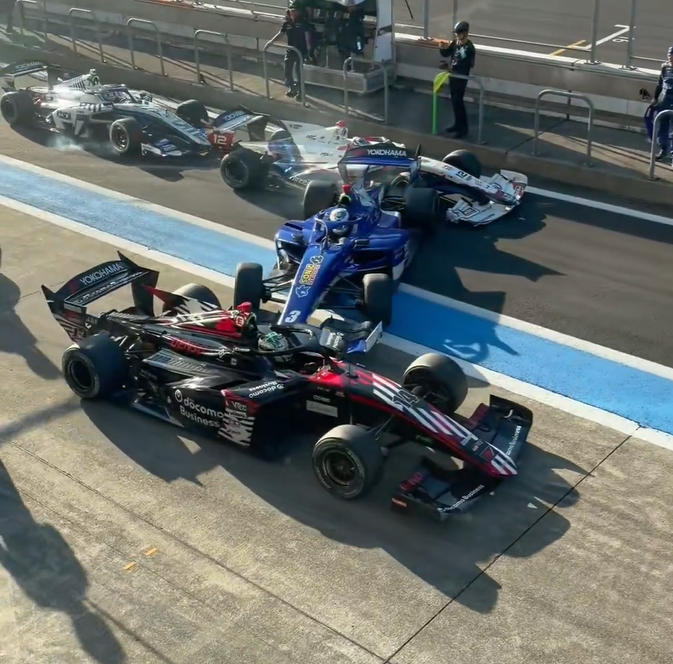 Drei Super-Formula-Rennwagen kollidieren in der Boxengasse während eines Rennens.