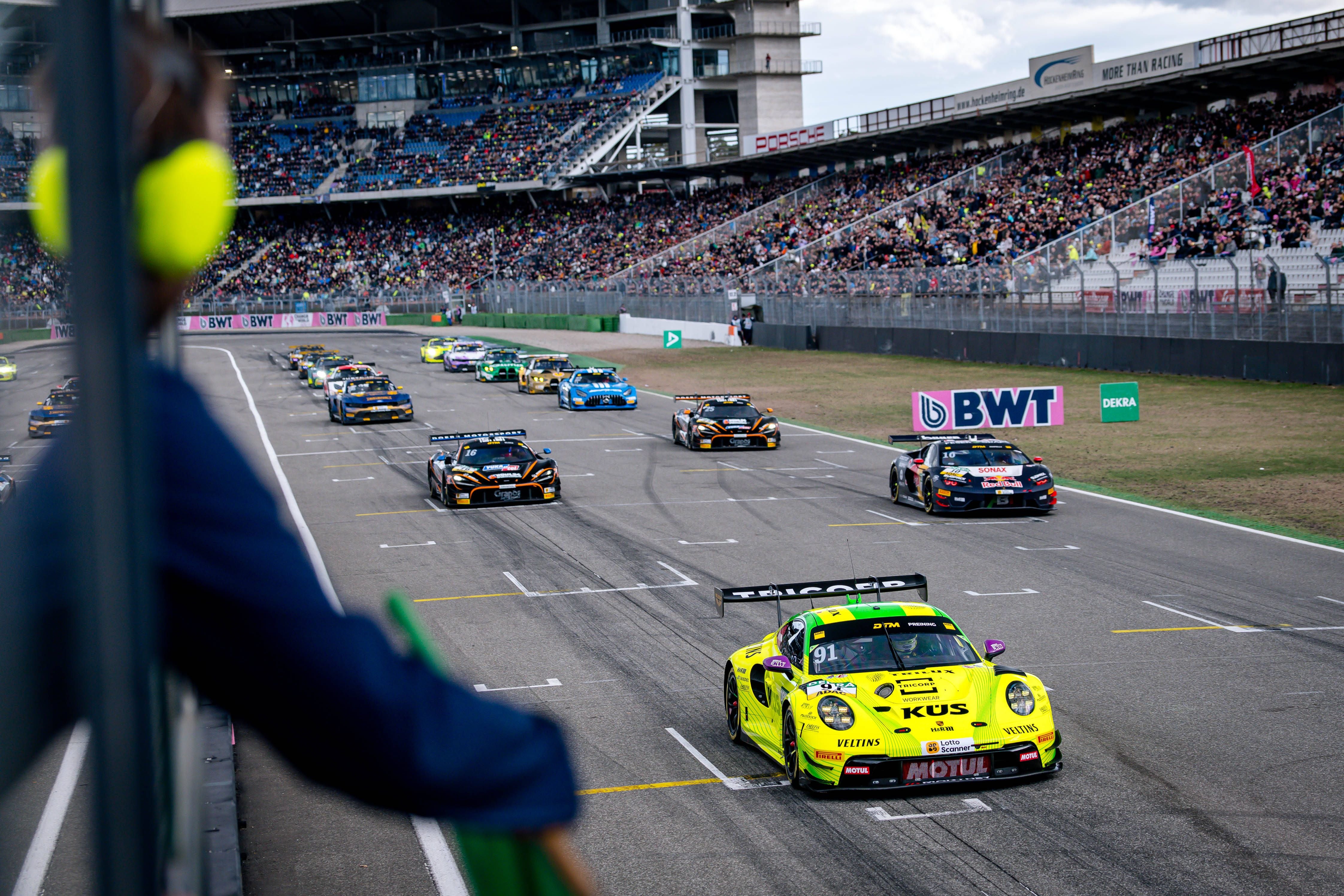 Start eines DTM-Rennens in Hockenheim mit einem gelben Porsche 911 GT3 R an der Spitze.