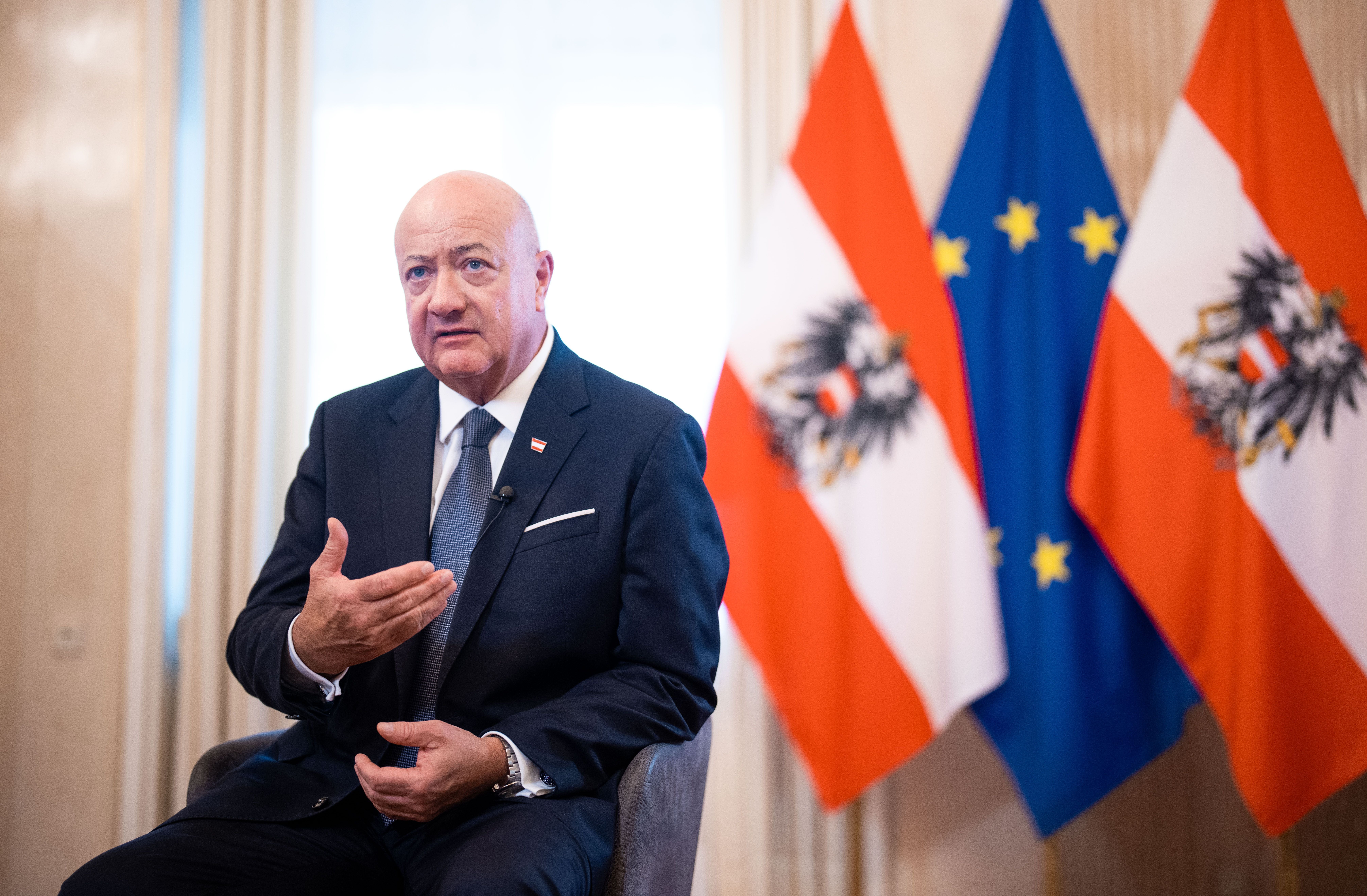 Bundeskanzler Christian Stocker (ÖVP) spricht, im Hintergrund österreichische und EU-Flaggen.