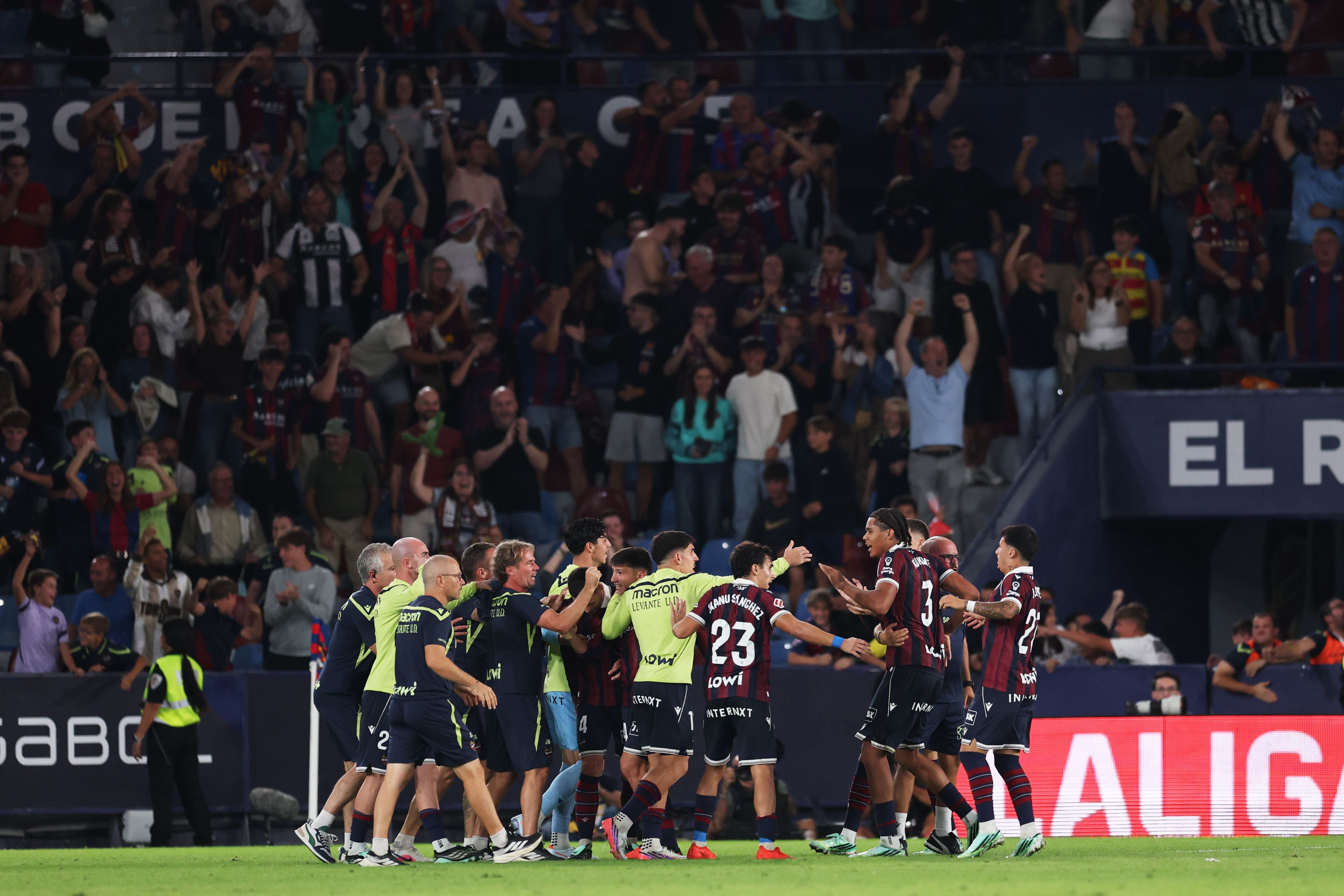 Ifeanyi Ndukwe steht im rot-blau gestreiften Trikot von Levante auf dem Platz und blickt nachdenklich mit gesenktem Kopf auf den Rasen.