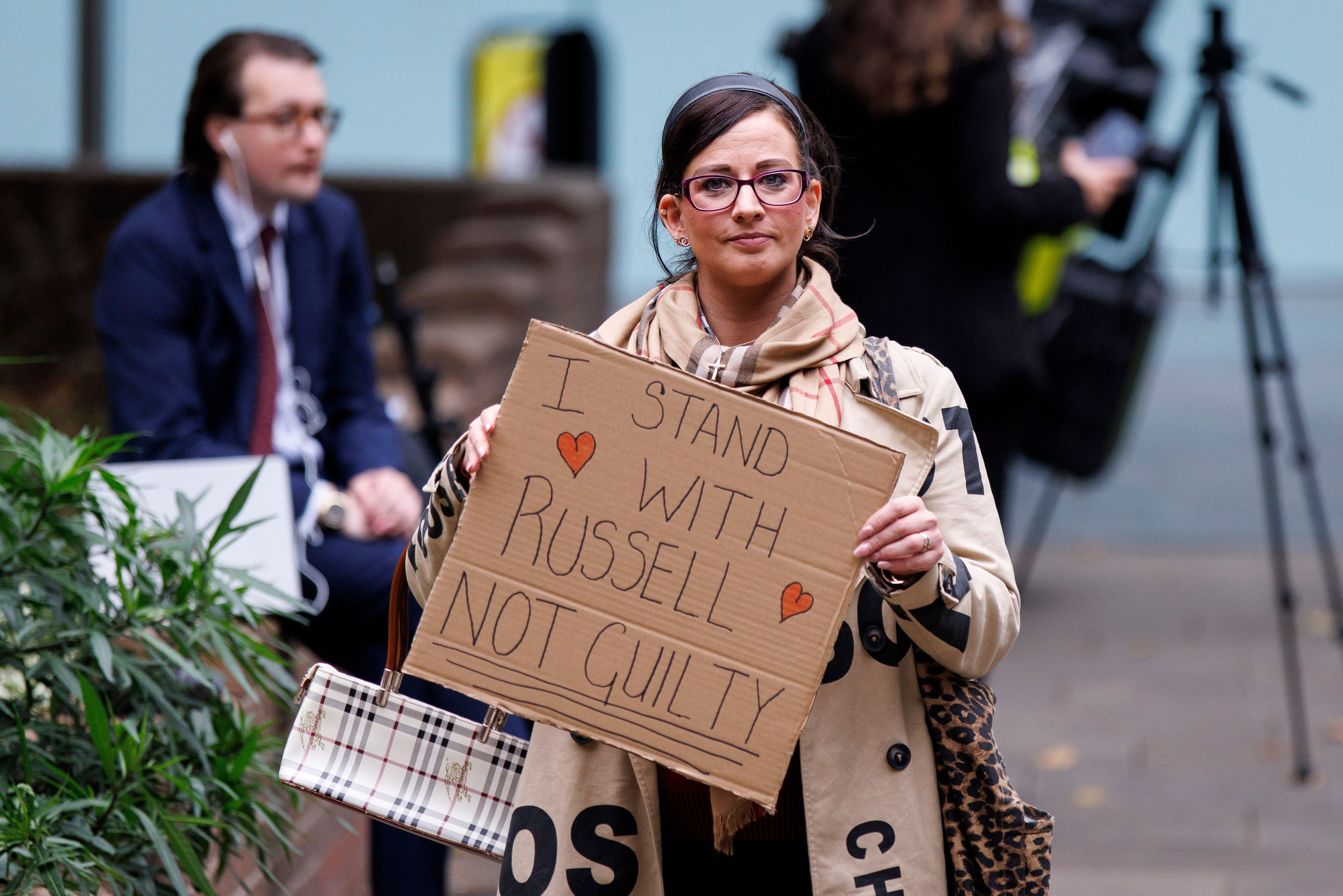 Frau mit Schild: „I stand with Russell Not Guilty“