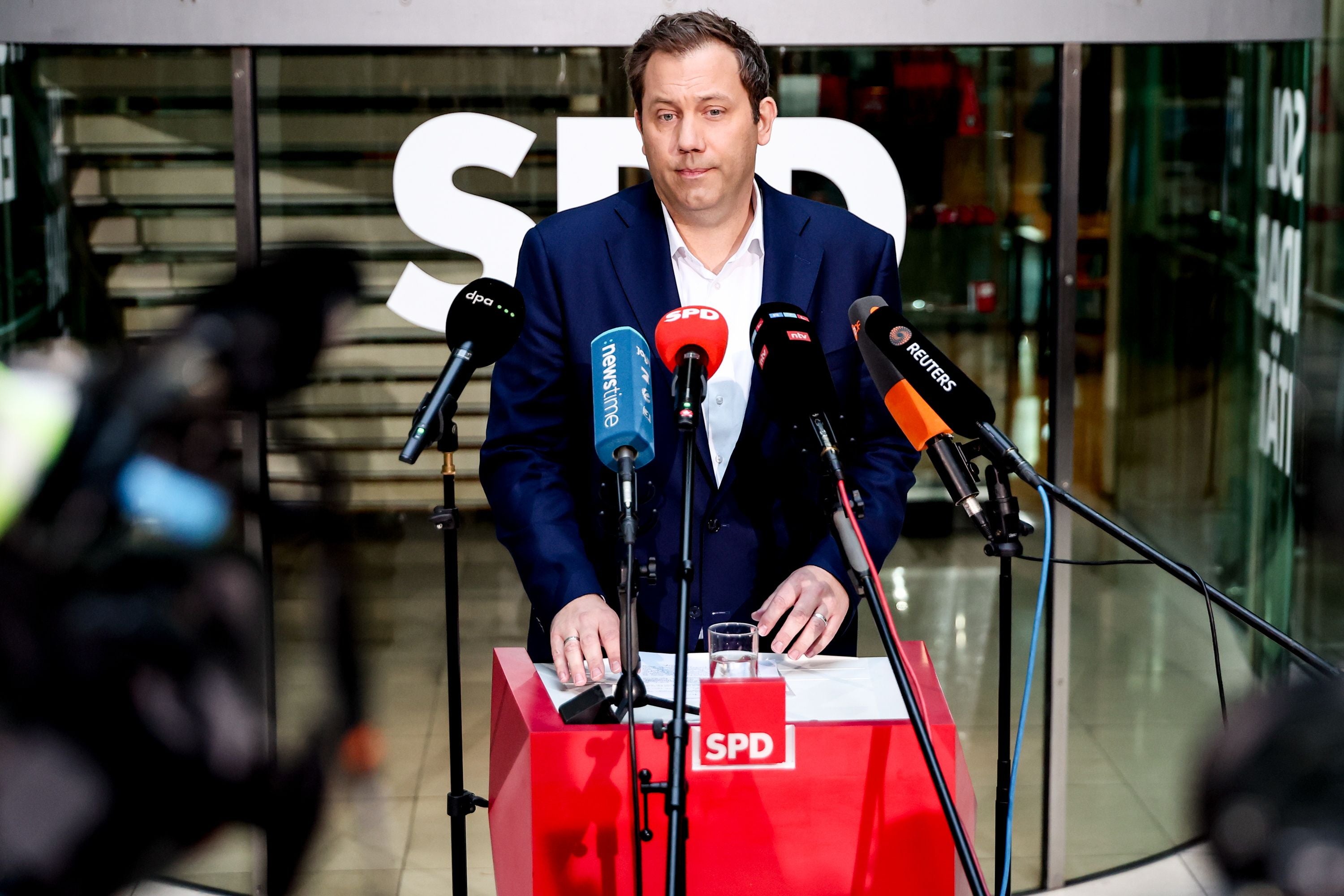 Ein Mann hält eine Pressekonferenz am Rednerpult der SPD mit mehreren Mikrofonen.