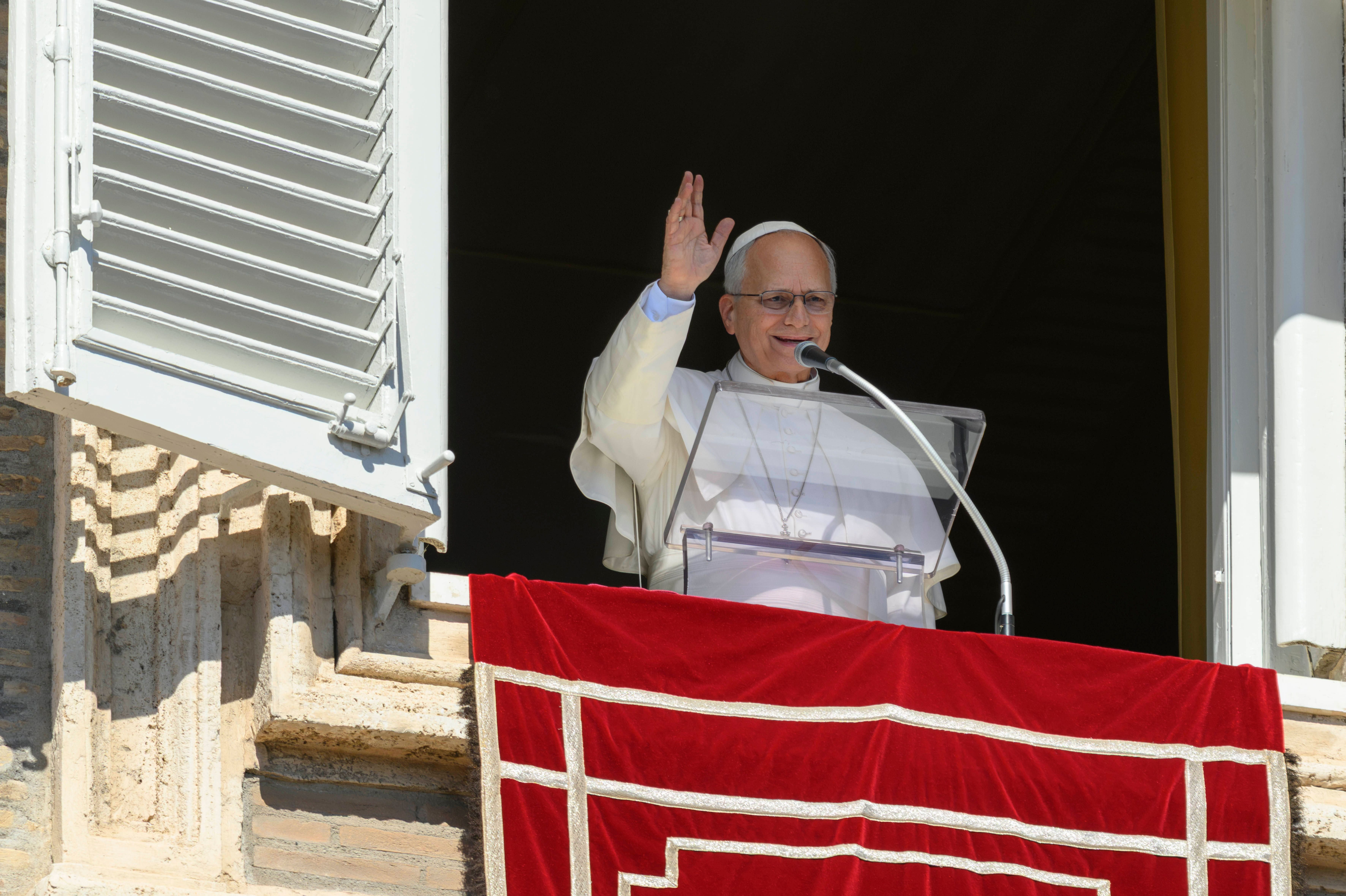 Papst hält Angelus-Ansprache am Fenster des Apostolischen Palasts mit erhobener Hand.