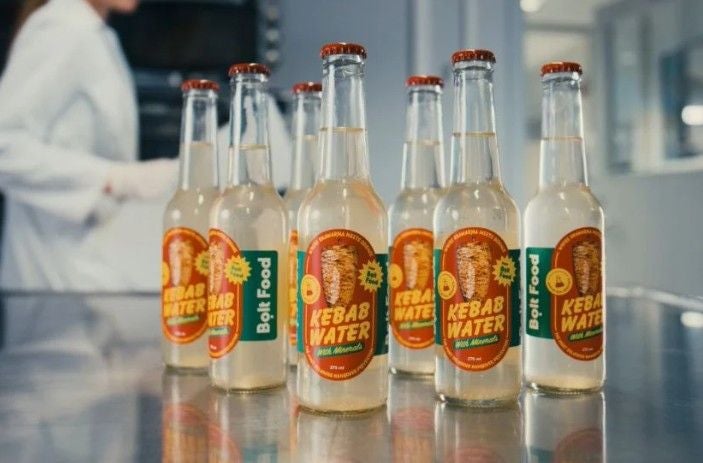 Sechs Flaschen mit der Aufschrift "Kebab Water" stehen auf einem Edelstahltisch im Labor.
