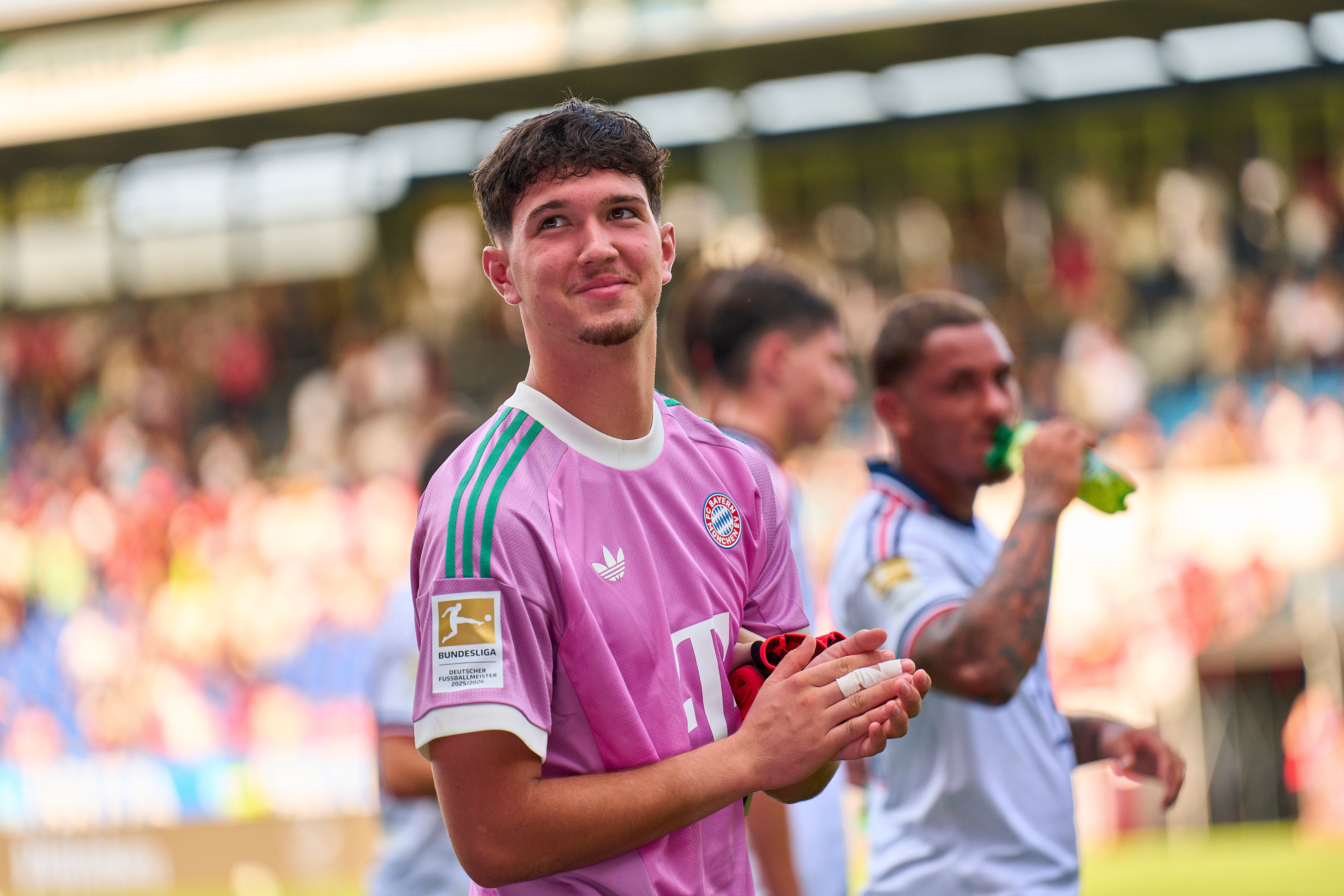 Ein junger Torwart des FC Bayern München applaudiert nach einem Fußballspiel im Stadion.