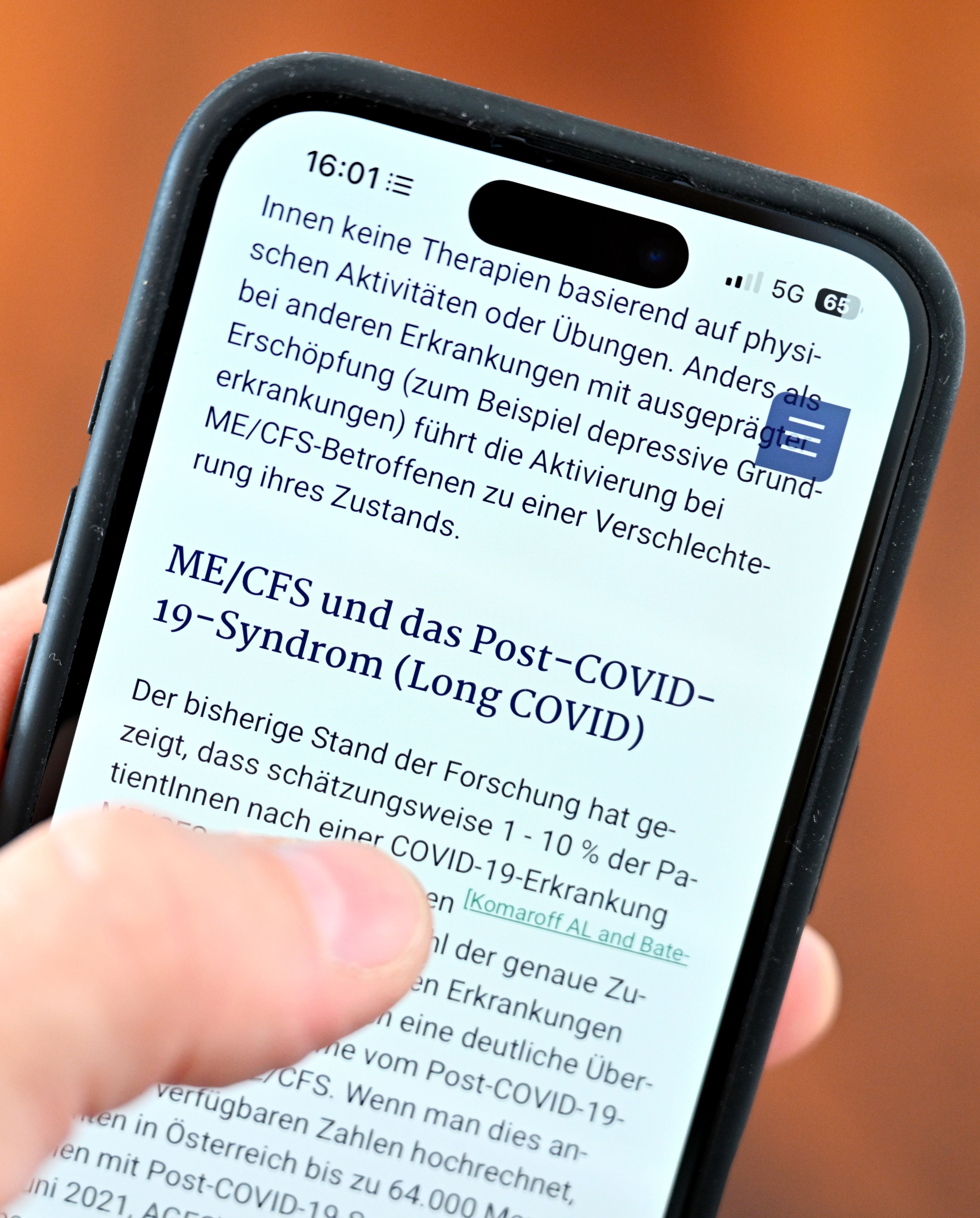 Ein Smartphone zeigt Informationen zu ME/CFS und Post-COVID-19-Syndrom (Long COVID) auf dem Display.