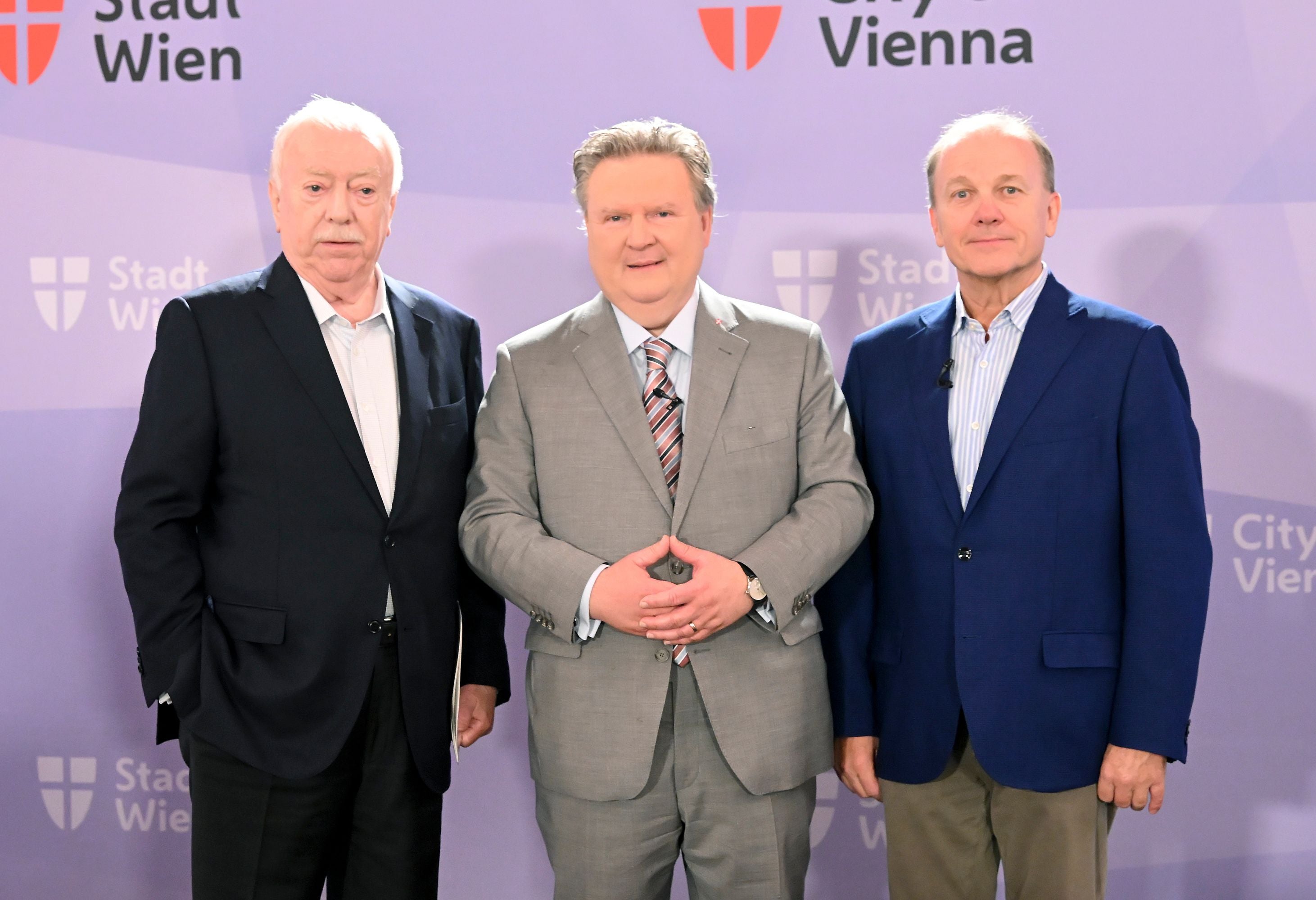 Drei Männer im Anzug stehen vor einem Hintergrund mit "Stadt Wien" und "City Vienna" Logos.
