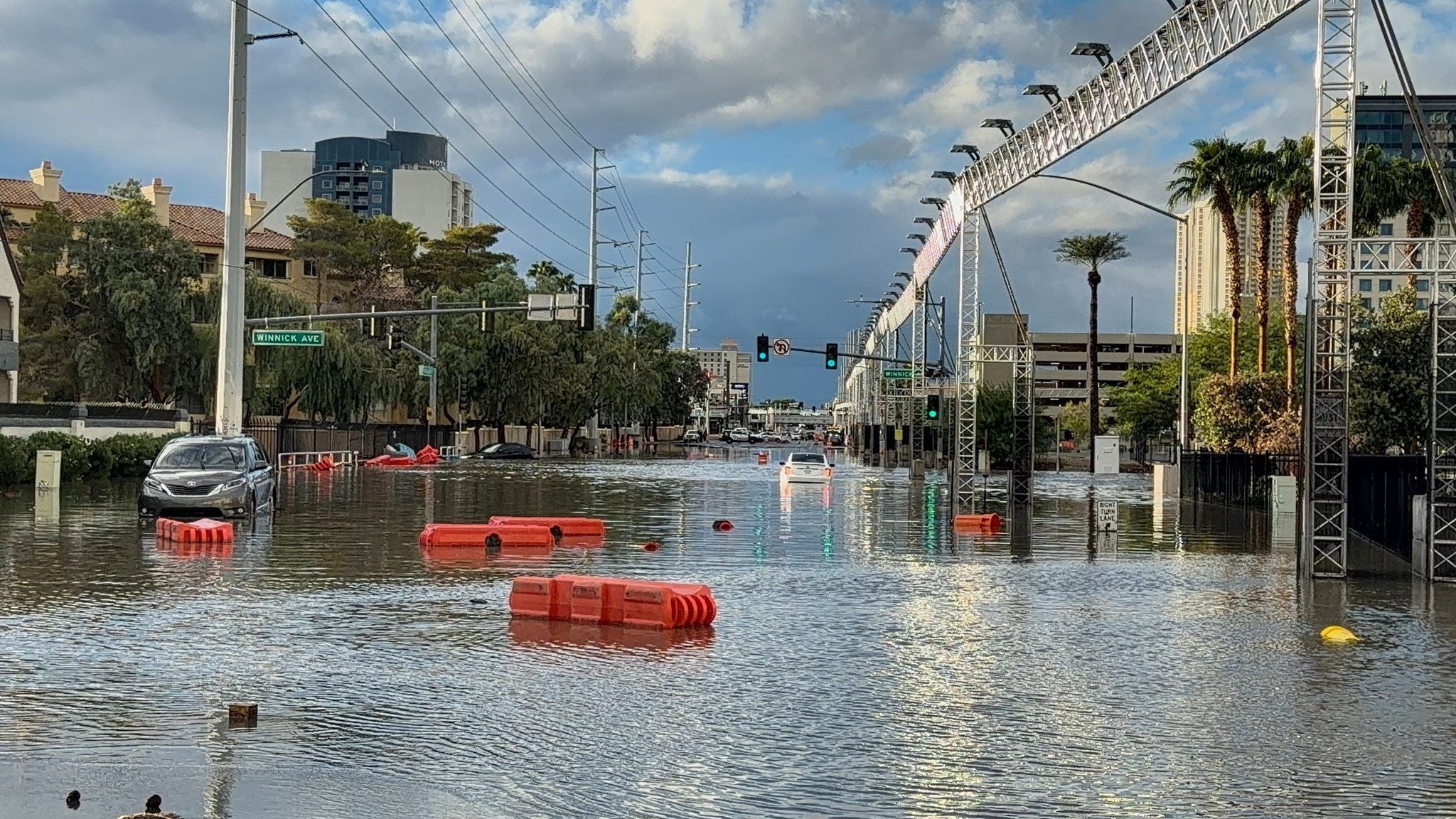 Überflutete Straße in Las Vegas mit abgesoffenem Auto und schwimmenden Absperrungen.