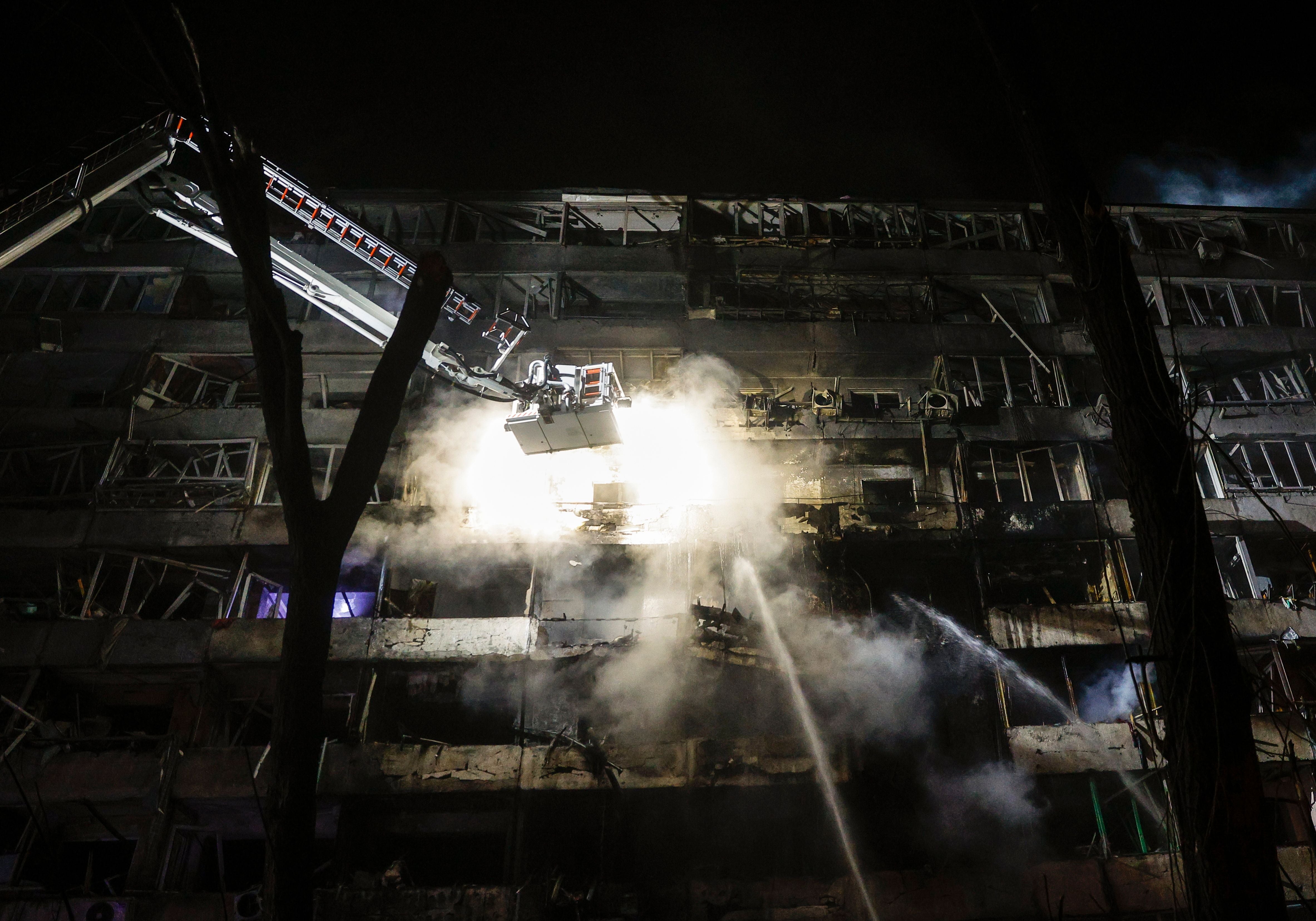 Feuerwehrmänner löschen brennendes Wohnhaus nach einem Raketenangriff.