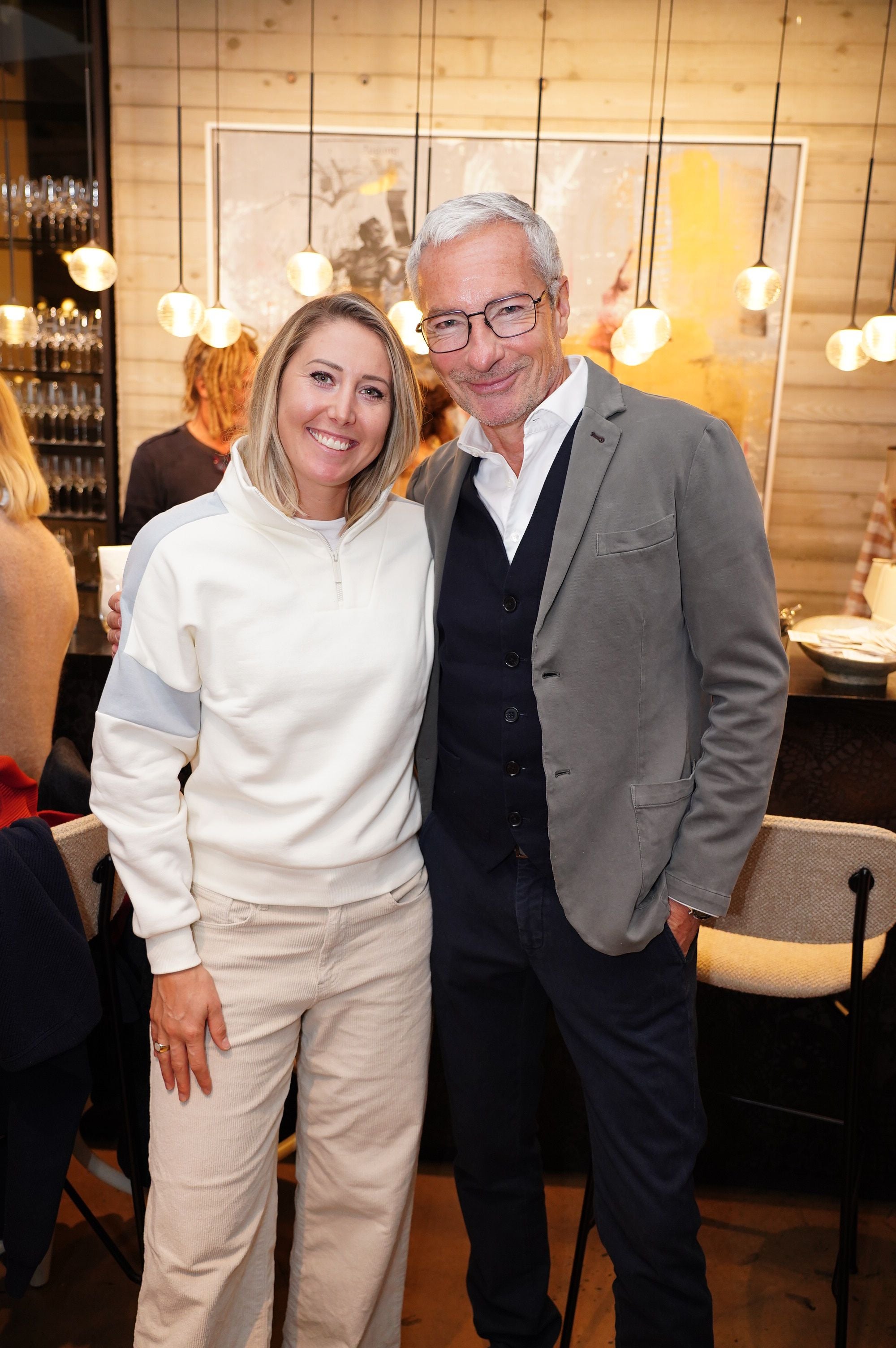 Ein Mann und eine Frau lächeln gemeinsam bei einem Colmar Pressebrunch in einem modernen Raum.