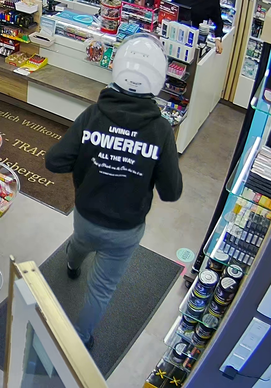 Der verdächtige Trafikräuber mit auffälligem Hoodie von hinten.
