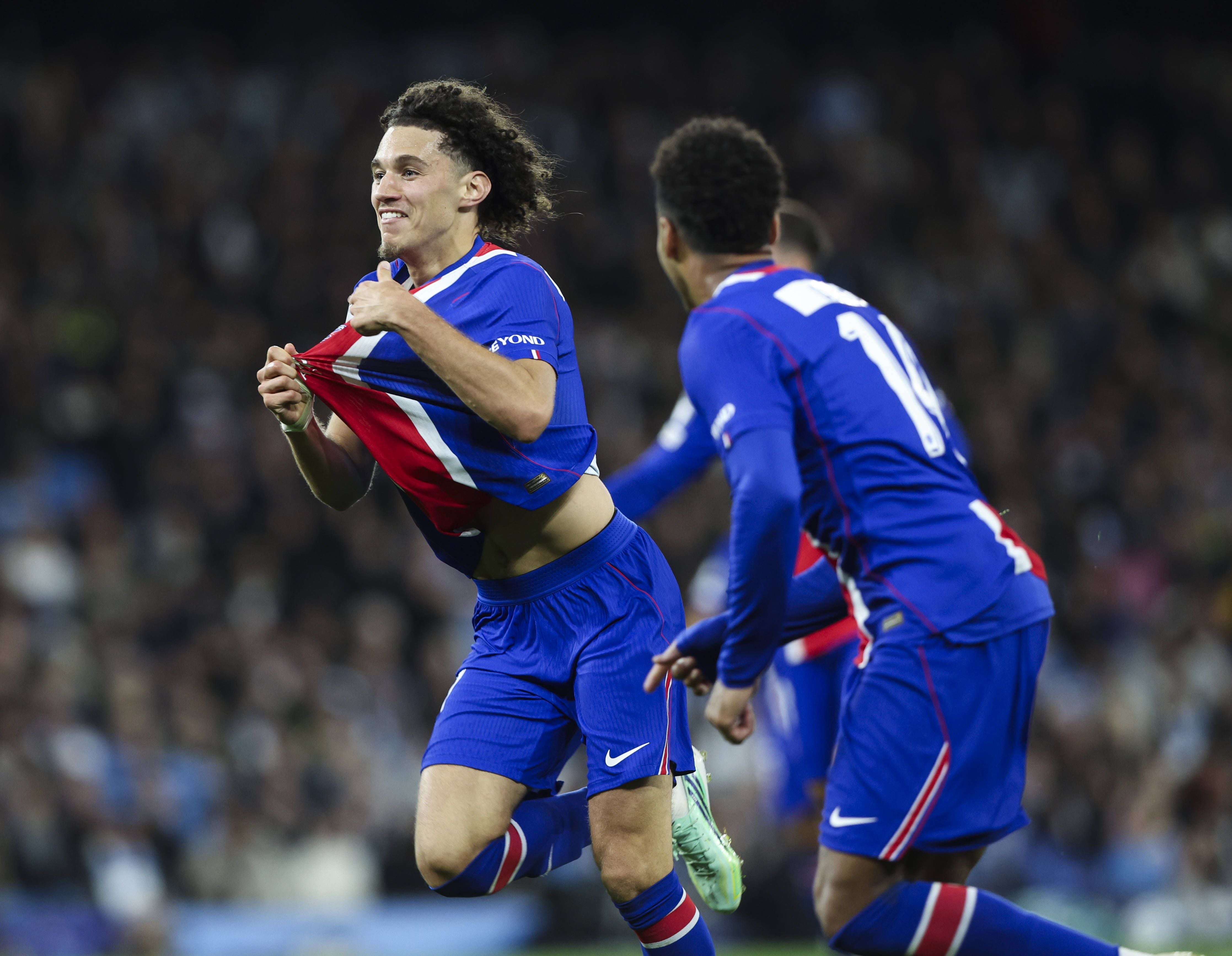 Maghnes Akliouche von Paris Saint-Germain zieht beim Jubel sein blosser Trikot nach oben, während ein Mitspieler hinter ihm herläuft.