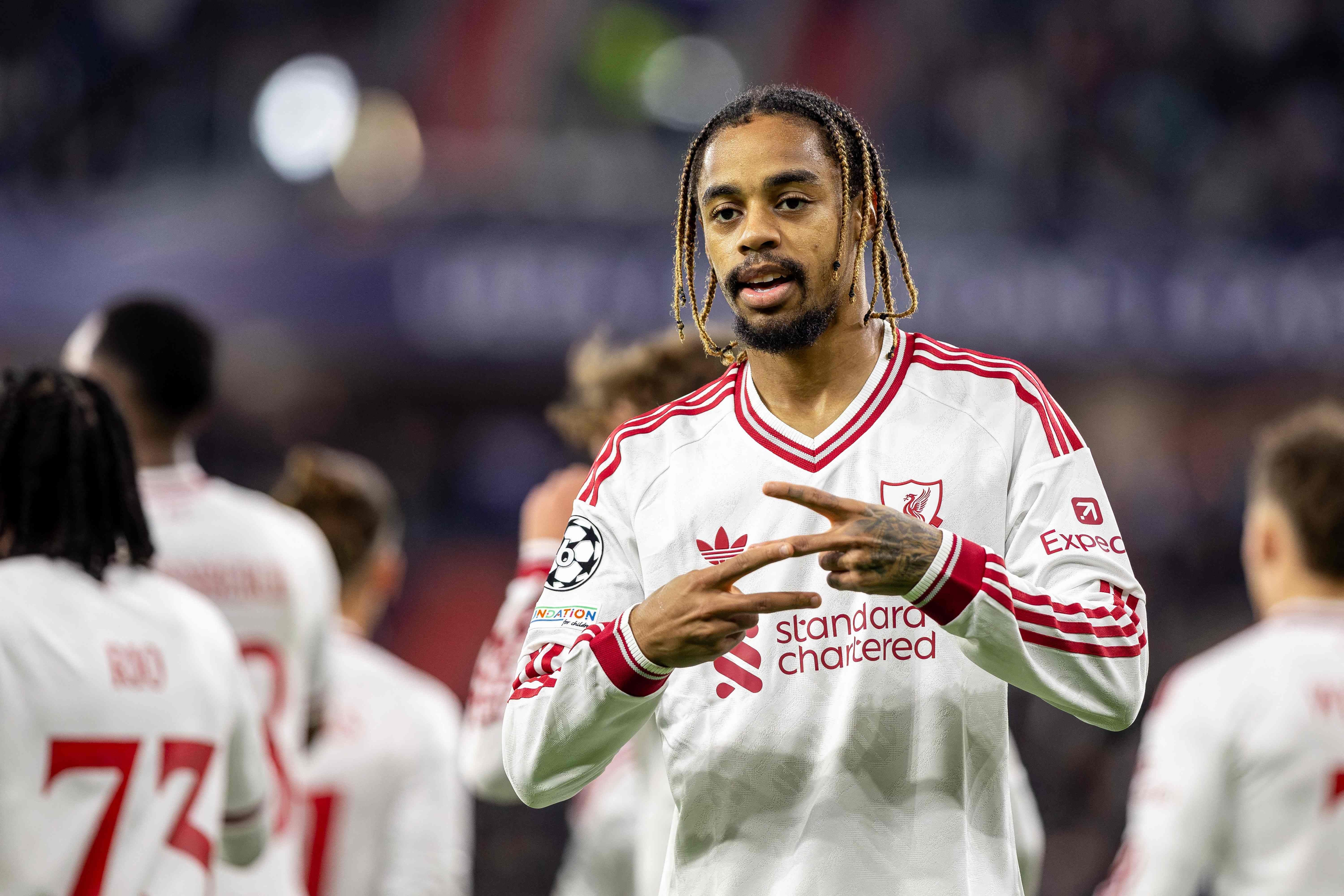 Ein Liverpool-Spieler jubelt nach einem Tor im weißen Auswärtstrikot auf dem Fußballfeld.