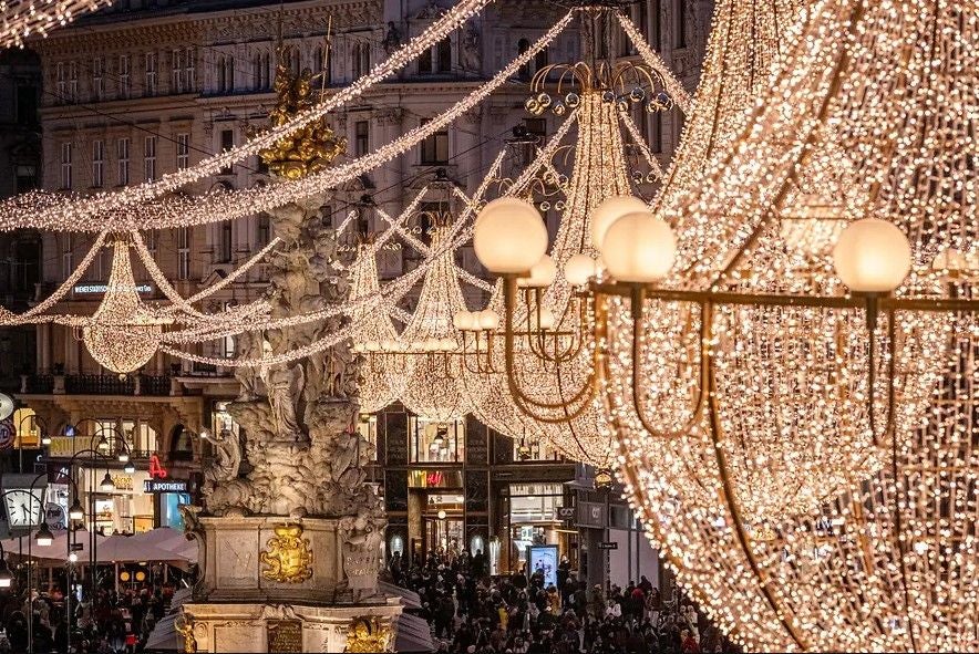 Prächtige Weihnachtsbeleuchtung und große Luster am Graben in Wien bei Abendstimmung.