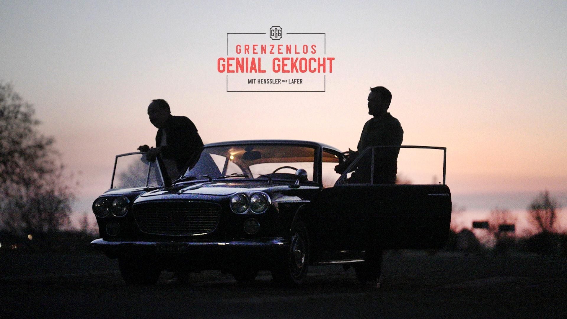 Zwei Männer stehen bei Sonnenuntergang neben einem Oldtimer mit geöffneten Türen.