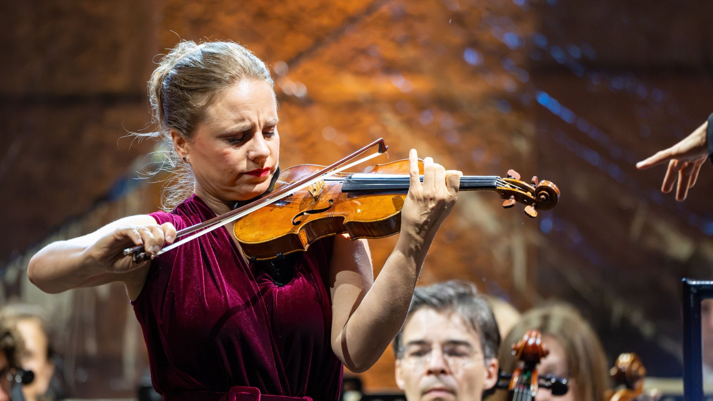 Eine Violinistin spielt konzentriert Geige bei einem klassischen Konzert.