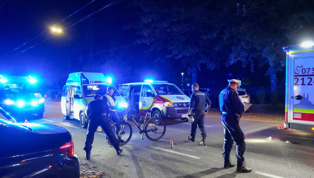 Polizisten und Rettungskräfte sichern nachts nach einem Fahrradunfall die Unfallstelle ab.