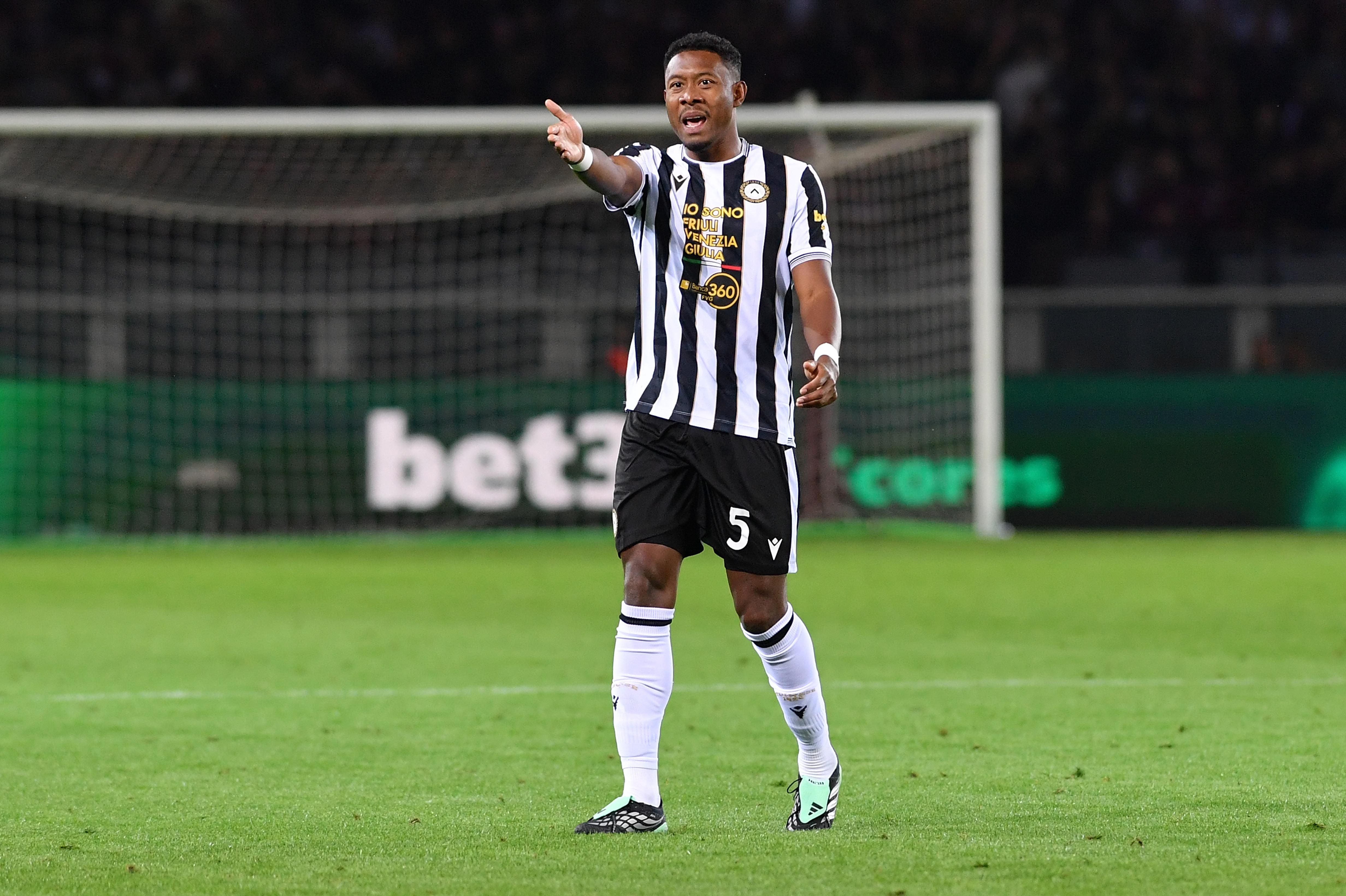 Ein Fußballspieler von Udinese im schwarz-weißen Trikot gestikuliert auf dem Spielfeld.