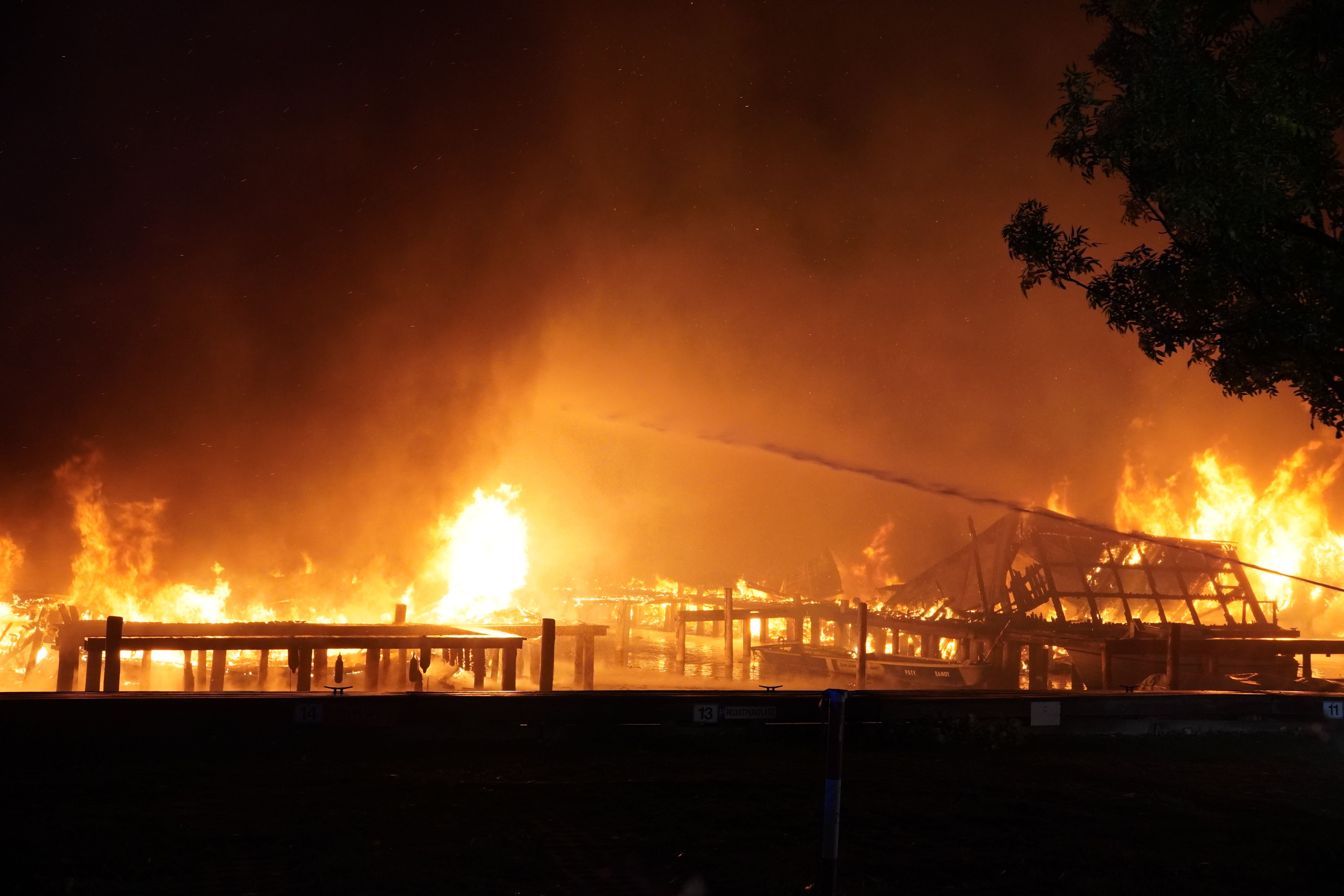 Großbrand in der Ruster Bucht am Neusiedler See bei Nacht, Feuer lodert an Bootslagern.