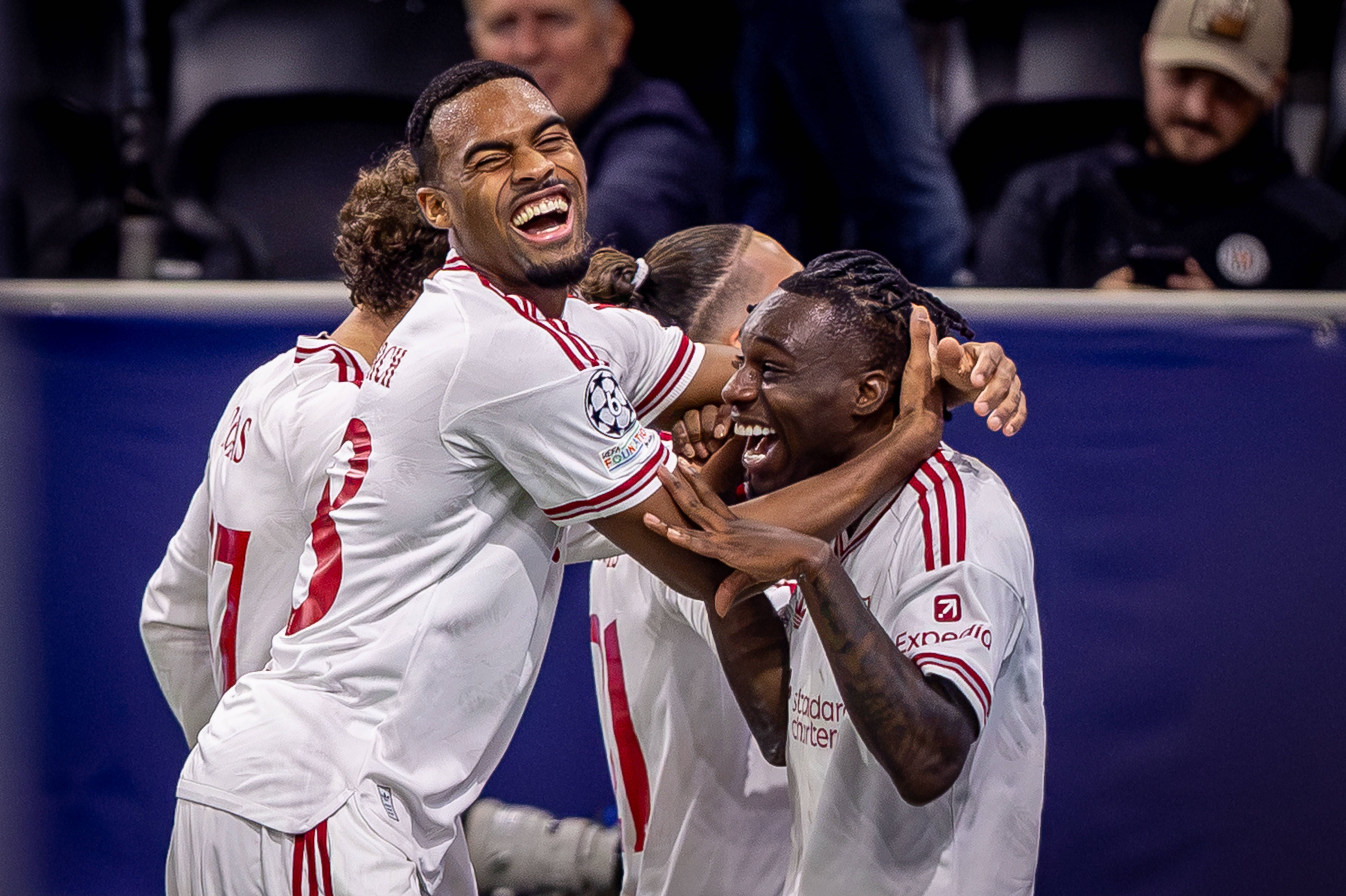 Vier Liverpool-Spieler jubeln lachend nach einem Tor während eines Champions-League-Spiels.