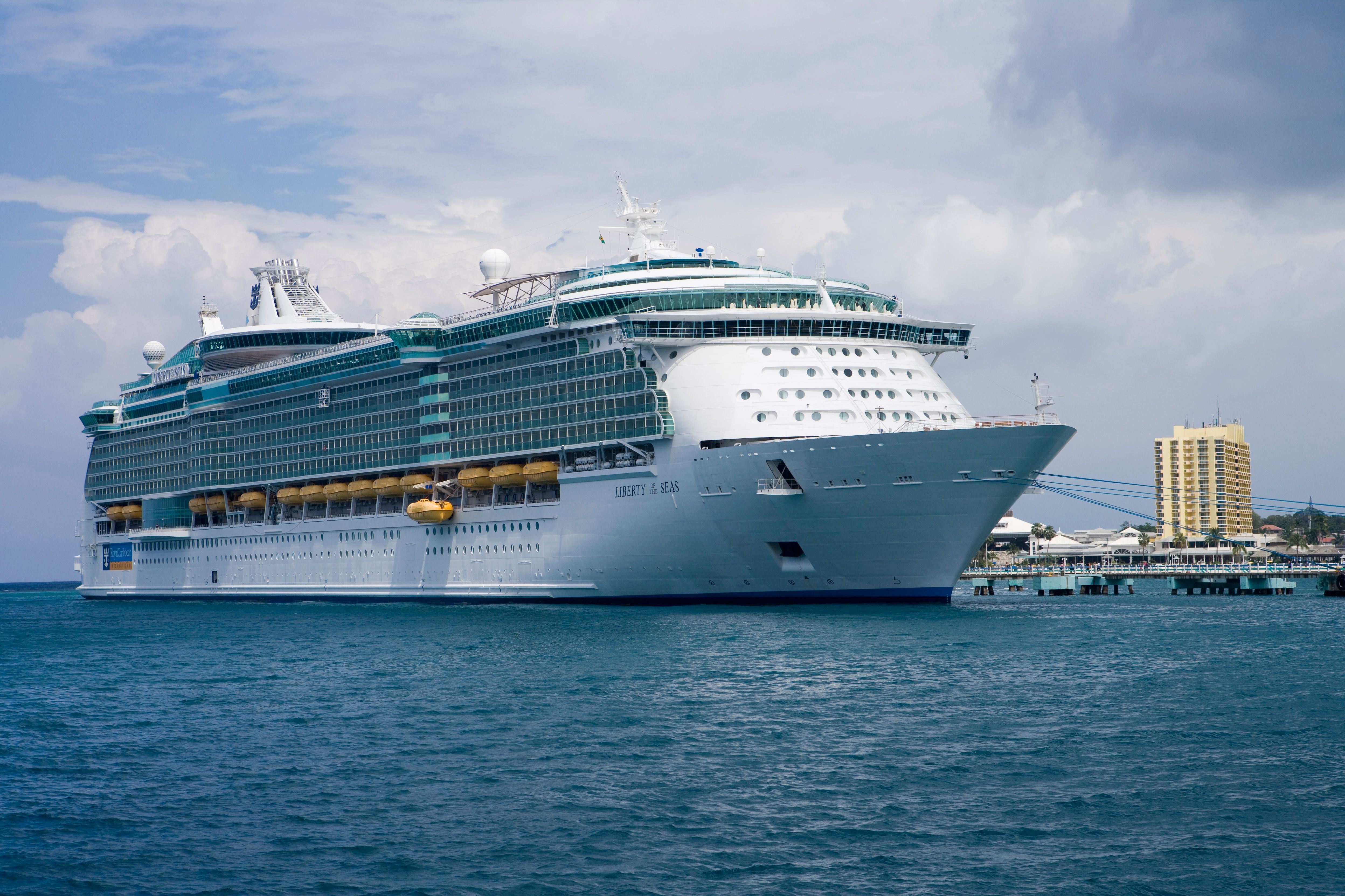 Großes Kreuzfahrtschiff liegt im Hafen von Ocho Rios, Jamaika, bei bewölktem Himmel.