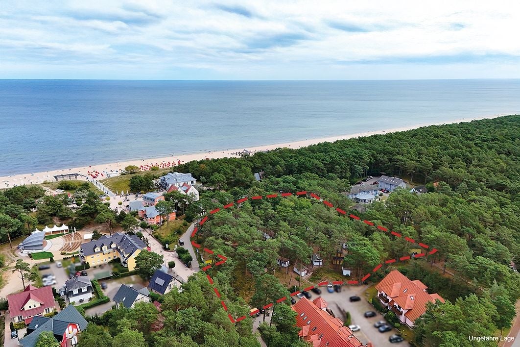 Luftaufnahme eines Ferienlagers an der Ostseeküste mit Strand und umgebenem Wald.