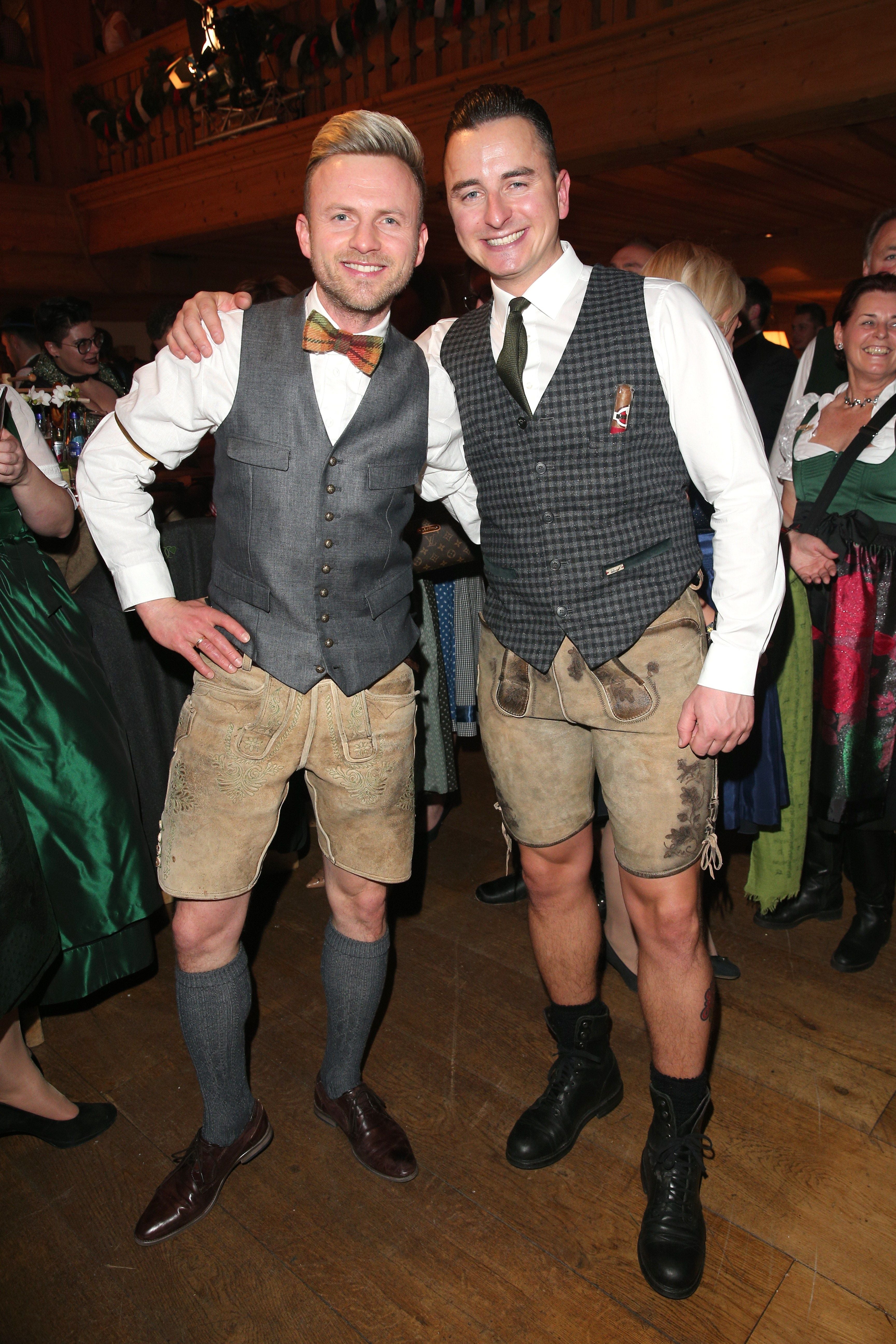 Zwei Männer in Tracht posieren bei einer festlichen Veranstaltung in Österreich.