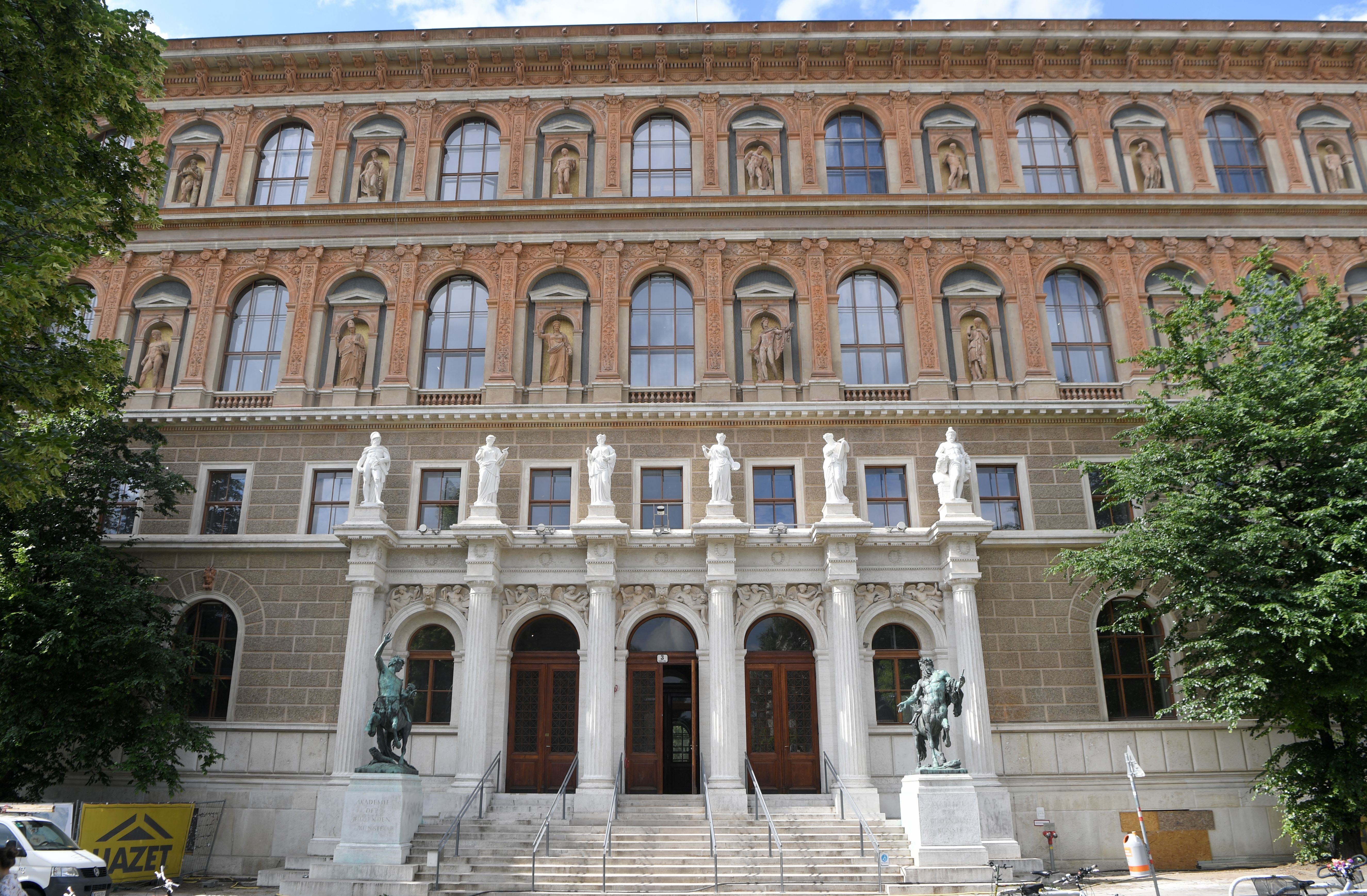 Außenansicht der renovierten Akademie der bildenden Künste Wien mit Statuen und Treppe am Eingang.