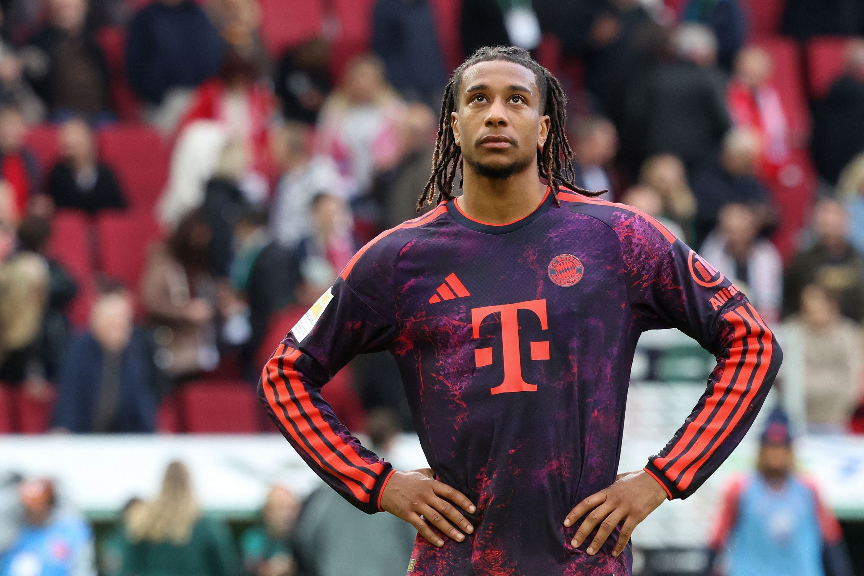Ein Bayern-Spieler steht nach einem Fußballspiel nachdenklich mit den Händen in der Hüfte auf dem Feld.