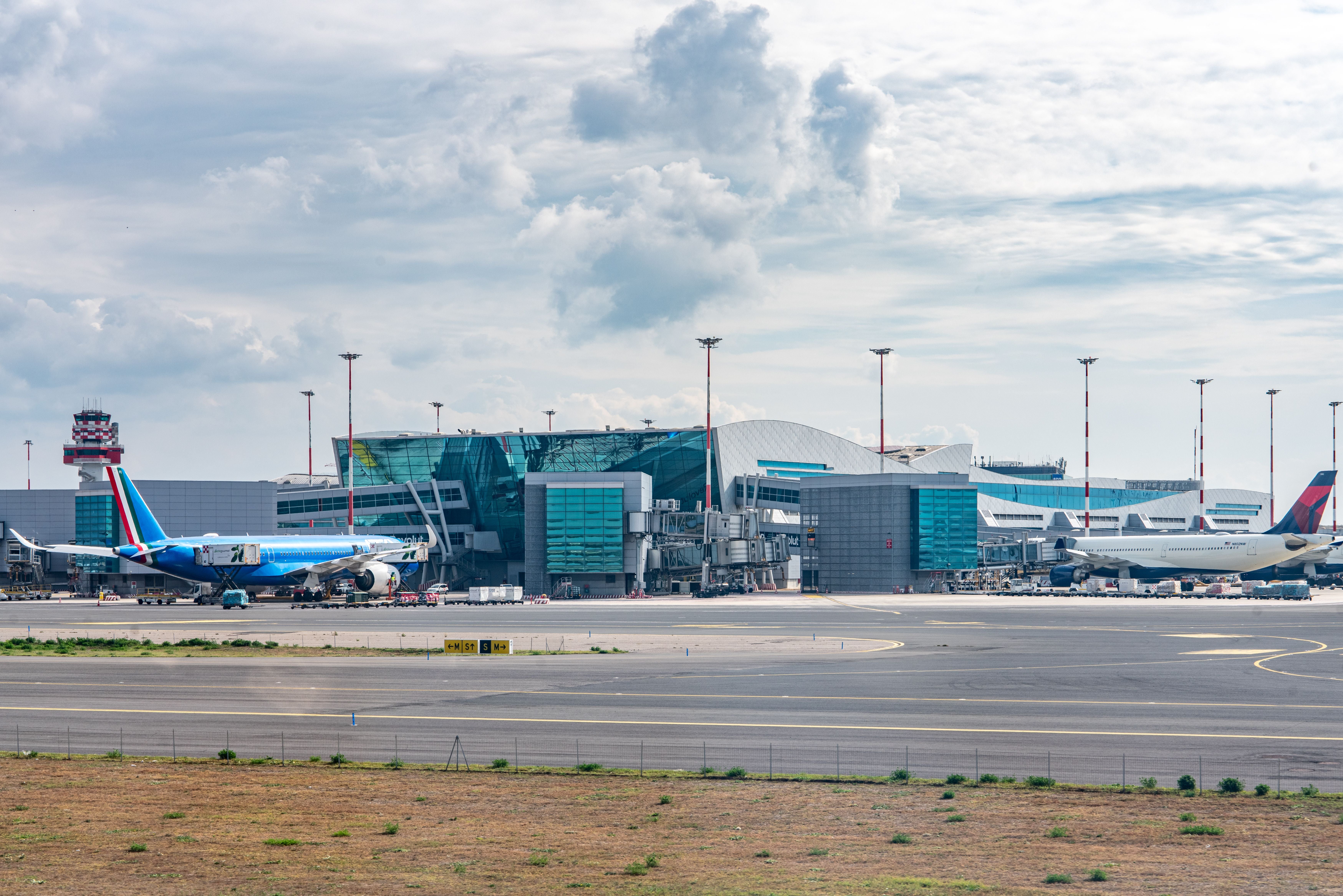 Flugzeuge stehen vor dem modernen Terminal des Flughafens Rom-Fiumicino in Italien.