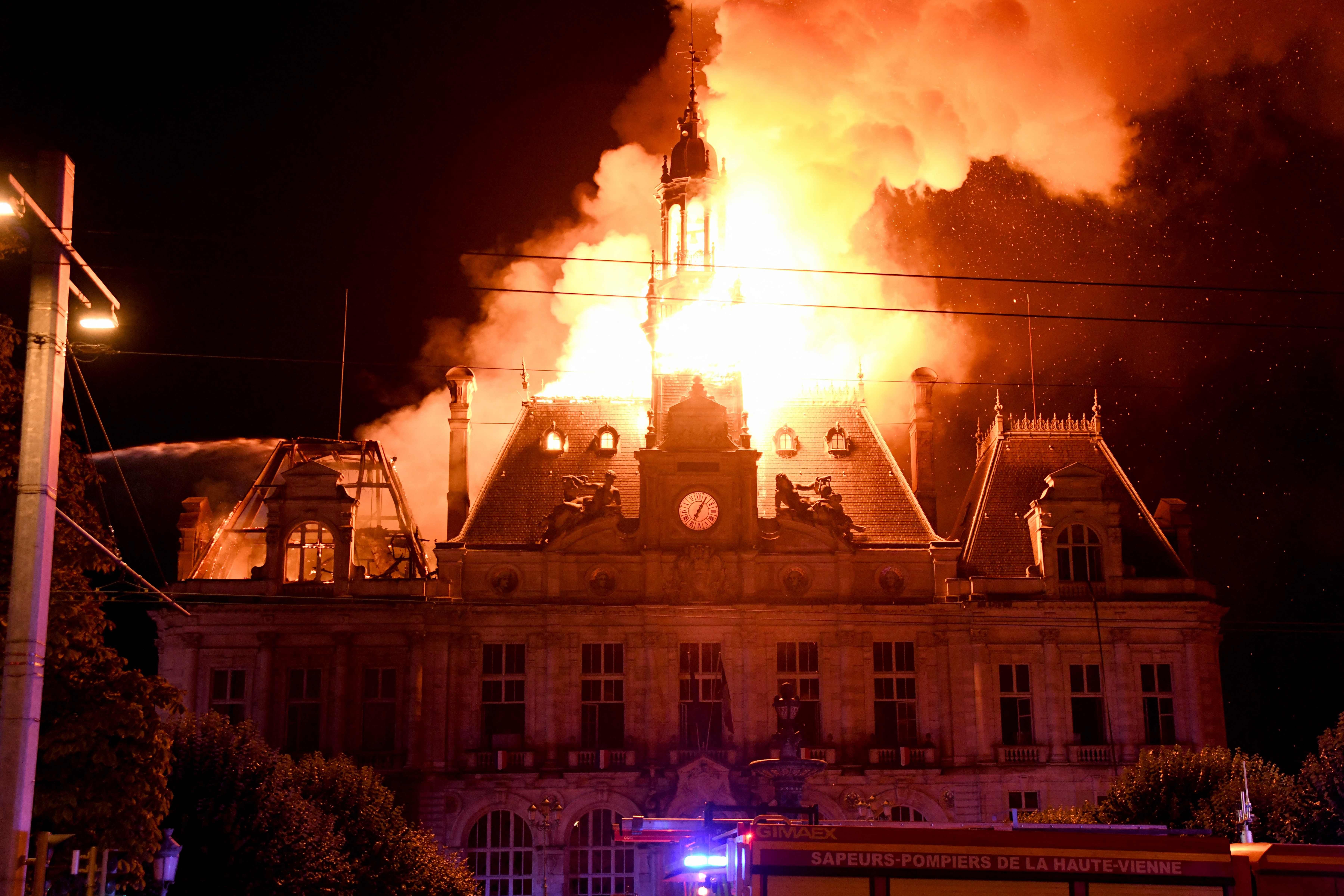 Großes Feuer zerstört das Rathaus von Limoges in der Nacht, Flammen schlagen aus dem Dach.