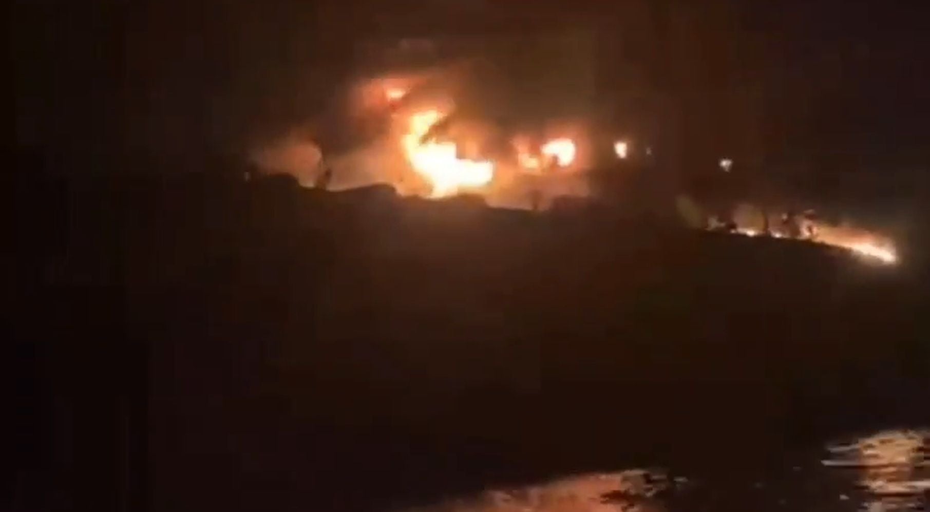 Nächtlicher Brand auf einem Schiff bei Hormuz, Flammen und Rauch sind zu sehen.