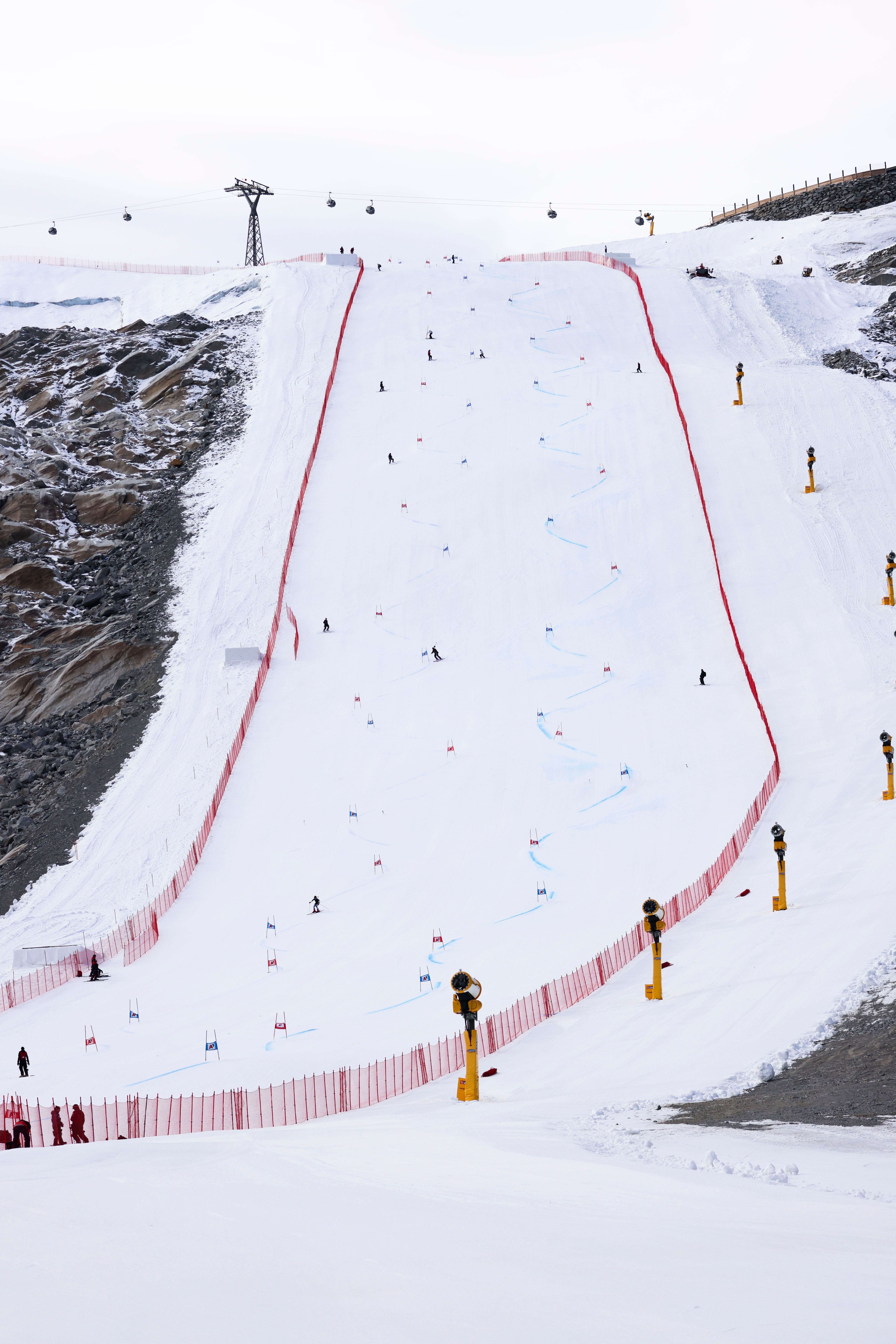 Verschneite Skipiste in Sölden mit roten Begrenzungen und mehreren Skifahrern beim Training.