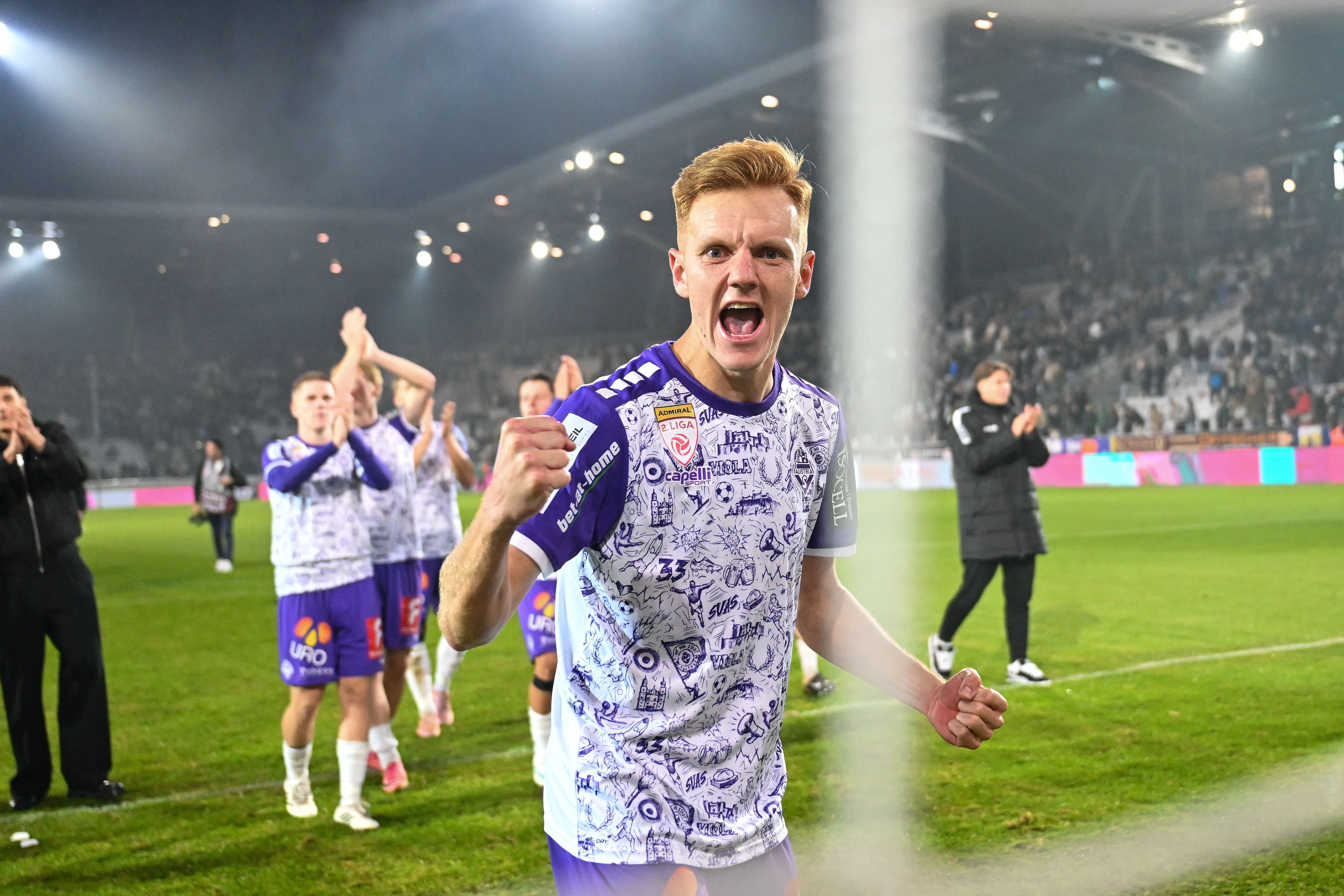 Ein jubelnder Fußballspieler im Austria Salzburg-Trikot auf dem Spielfeld nach dem Spiel.