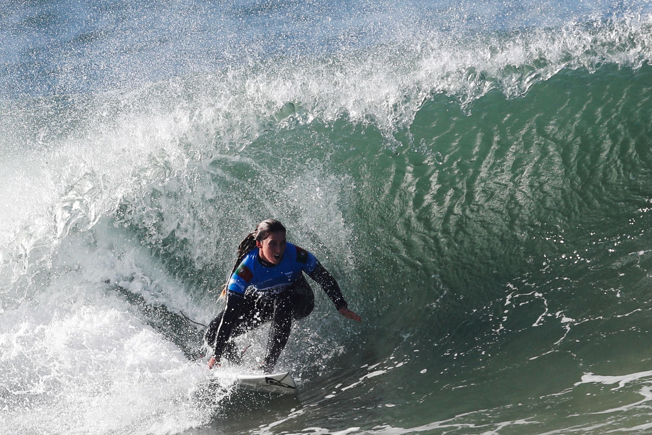 Surferin reitet eine große Welle beim Surf-Wettbewerb in Peniche, Portugal.