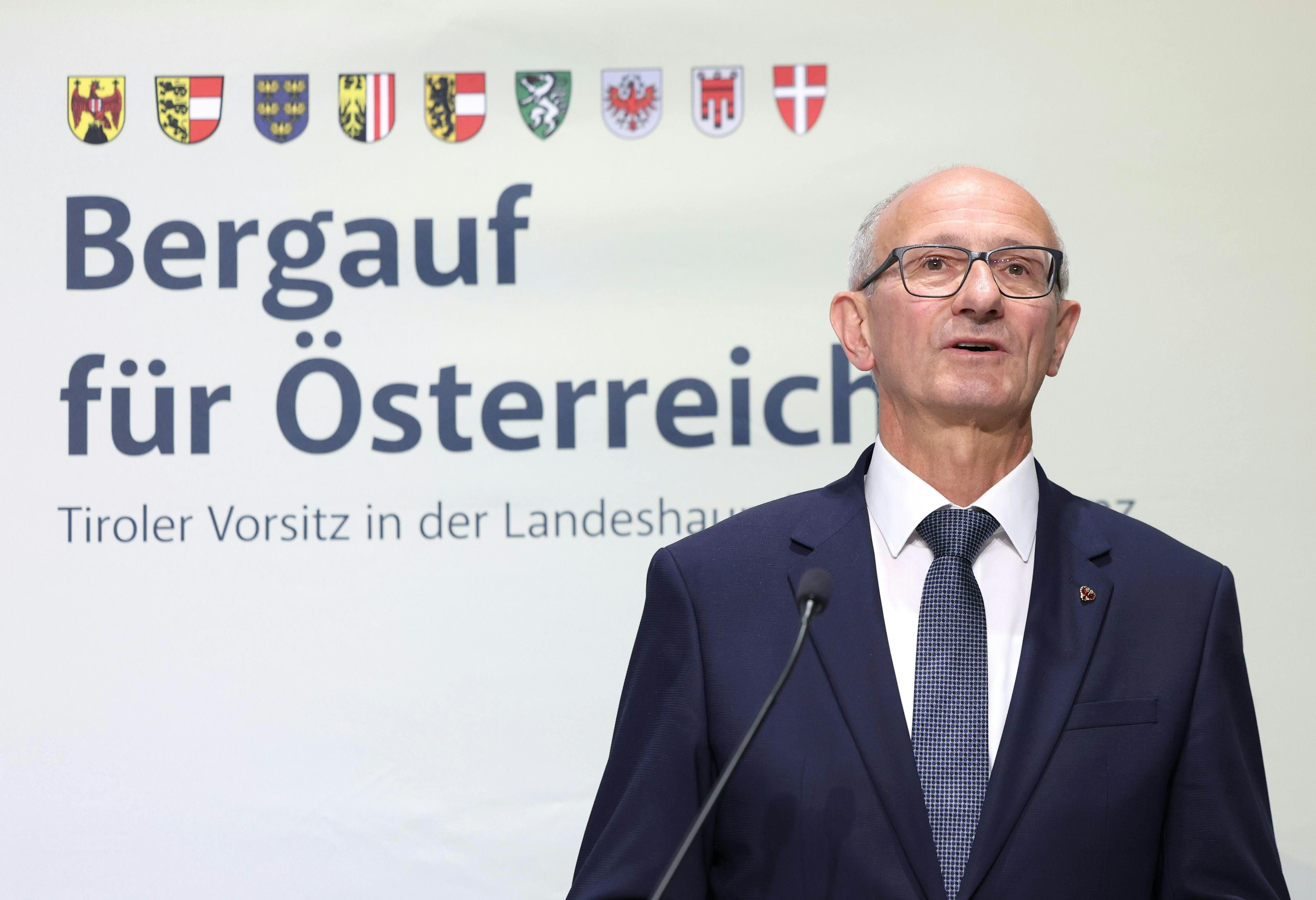 Ein Mann im Anzug spricht bei einer Pressekonferenz vor dem Schriftzug „Bergauf für Österreich“.