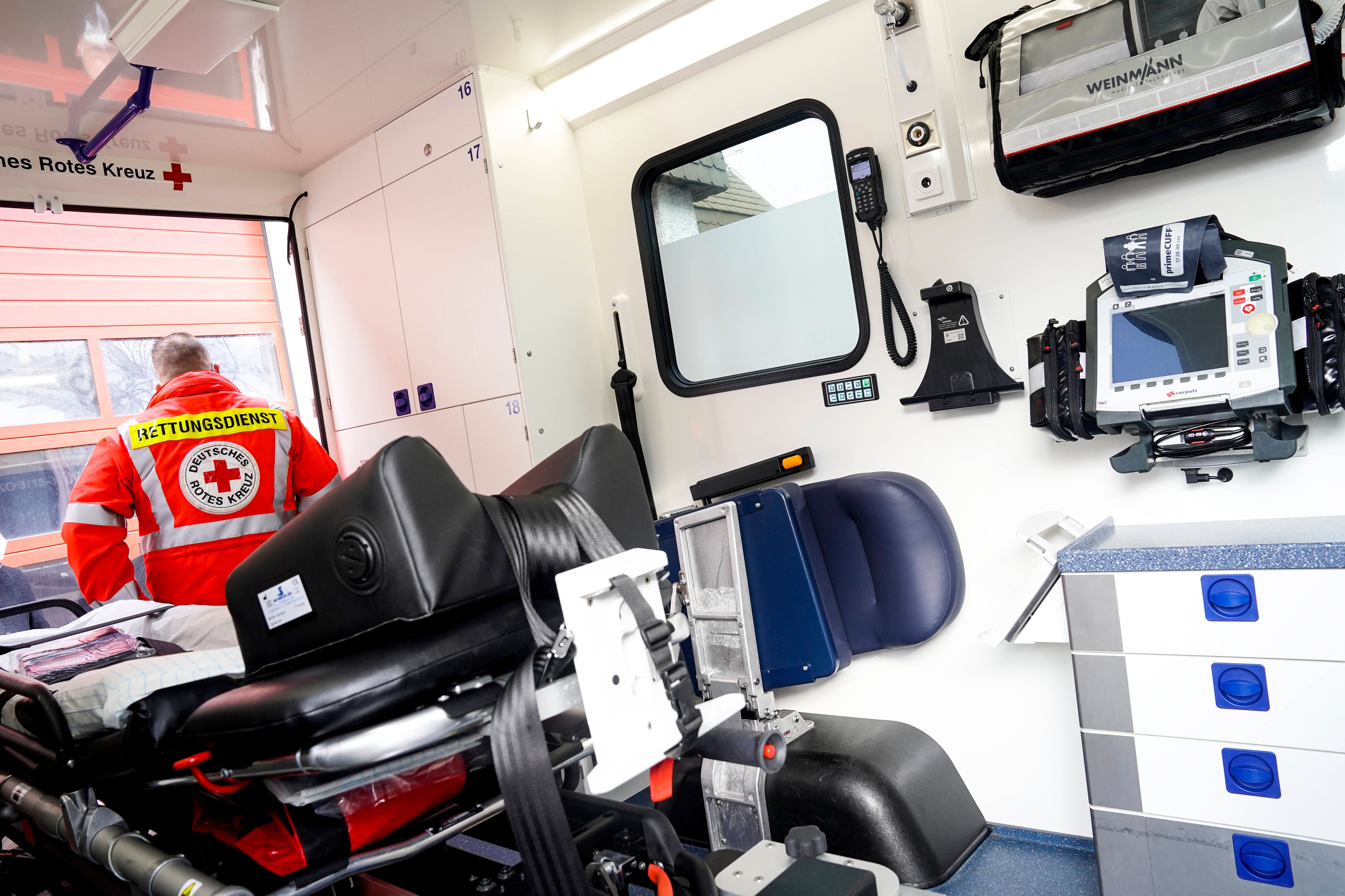 Sanitäter im Deutschen Roten Kreuz Intensivtransportwagen mit medizinischer Ausrüstung und Trage.