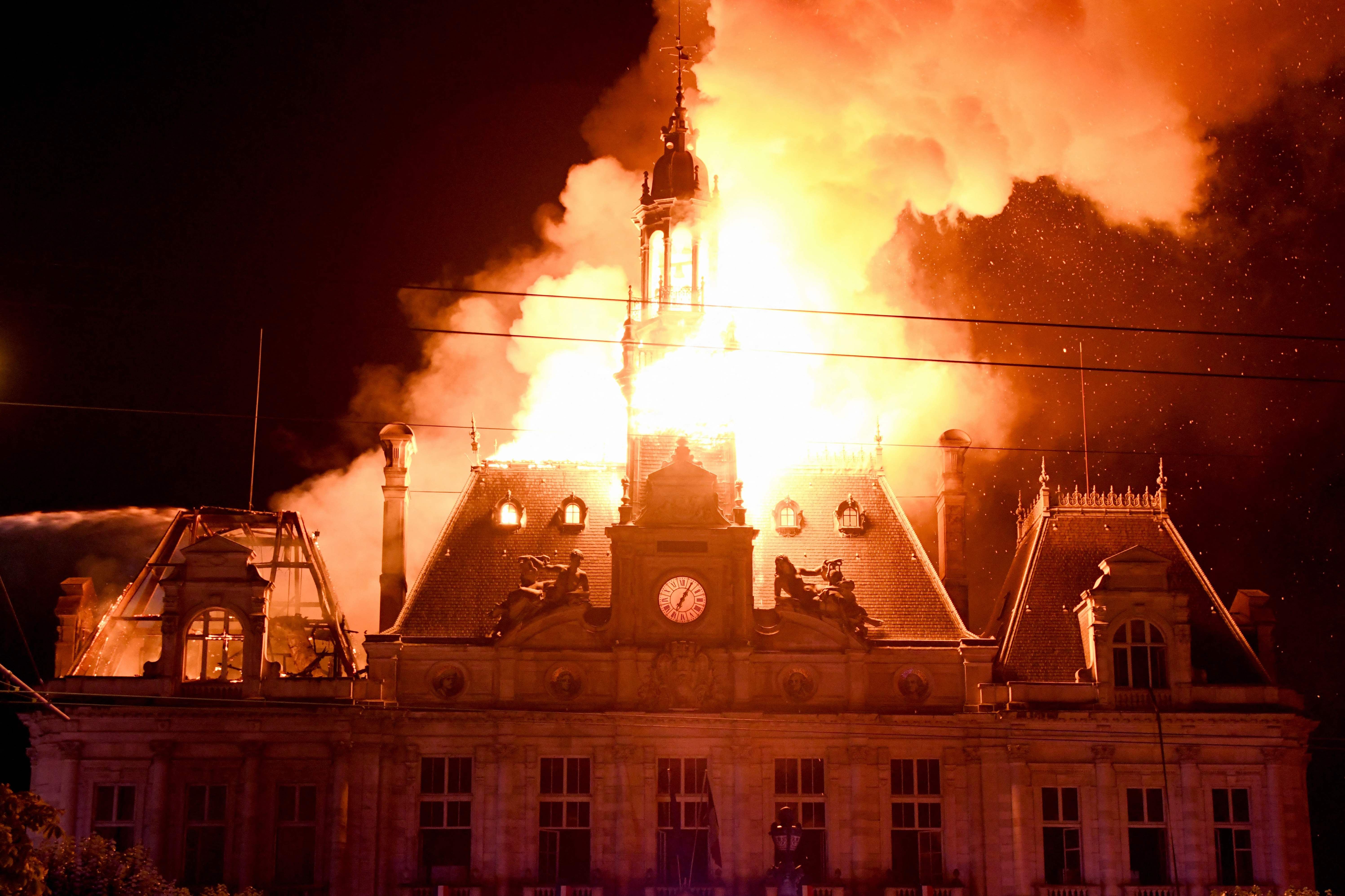 Das Rathaus von Limoges steht nachts in Flammen, dichter Rauch steigt auf.
