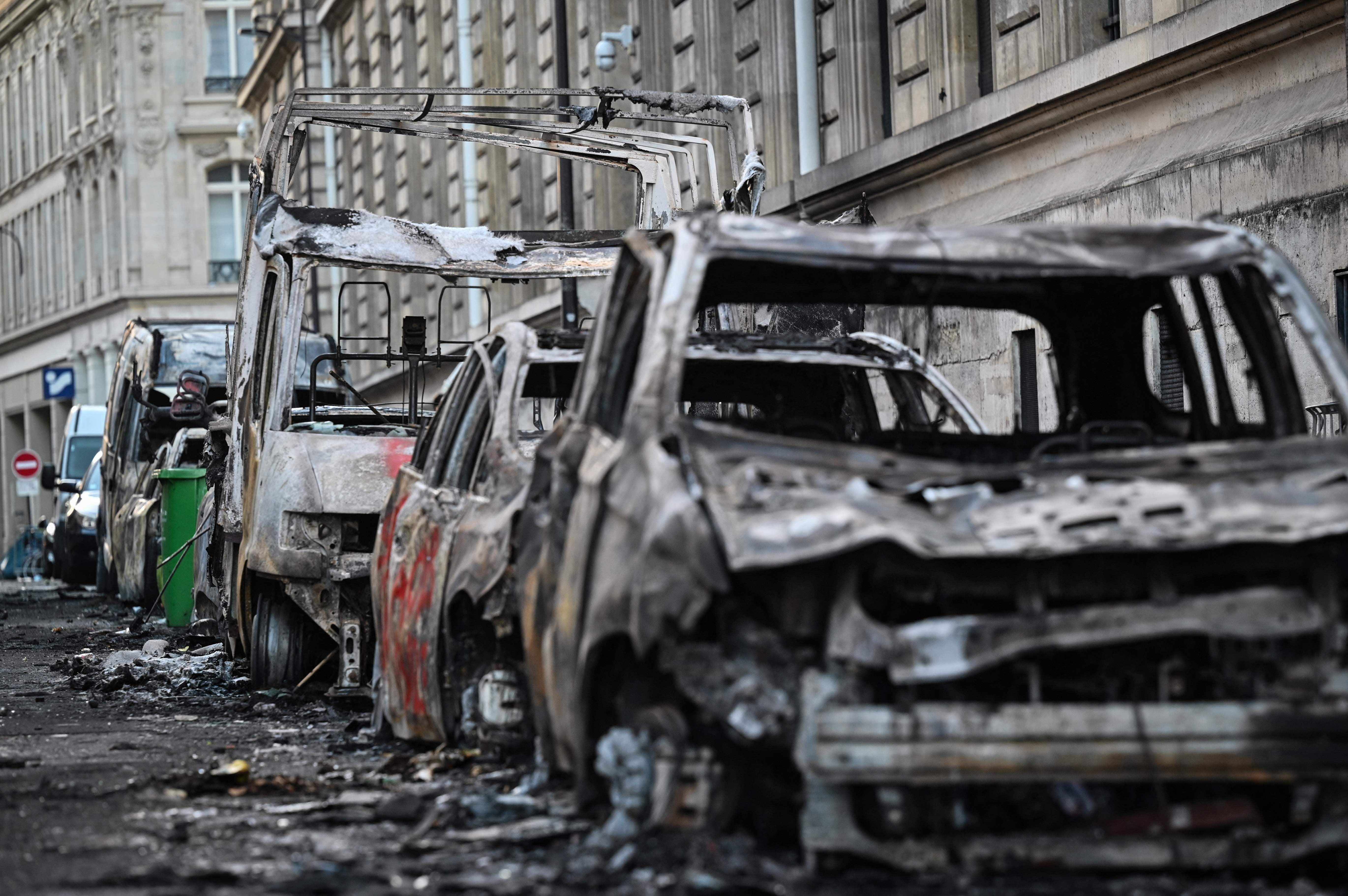 Ausgebrannte Fahrzeuge stehen auf einer Pariser Straße nach heftigen Protesten und Bränden.