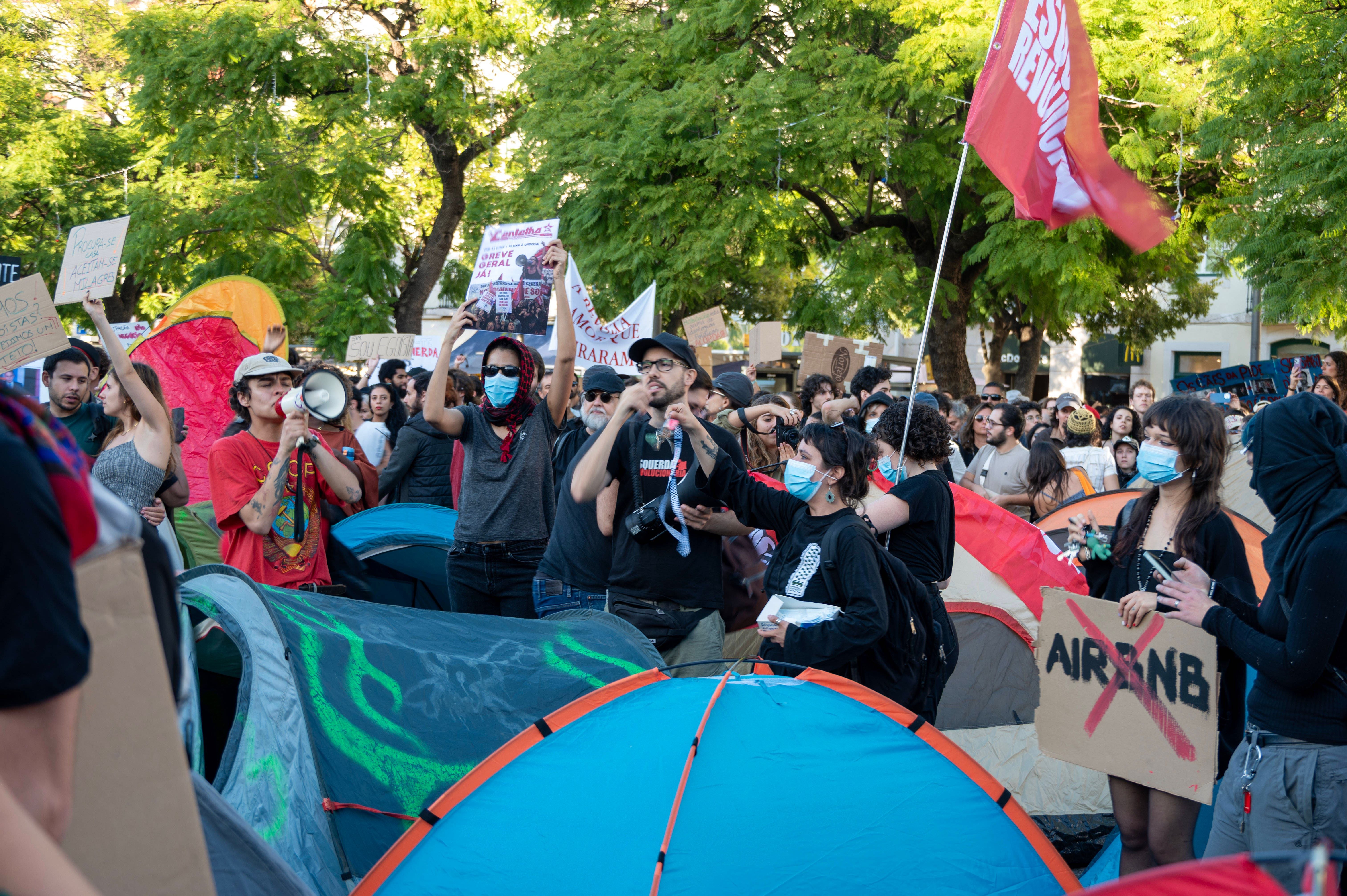Demonstranten protestieren in Lissabon für bezahlbaren Wohnraum mit Zelten und Schildern.