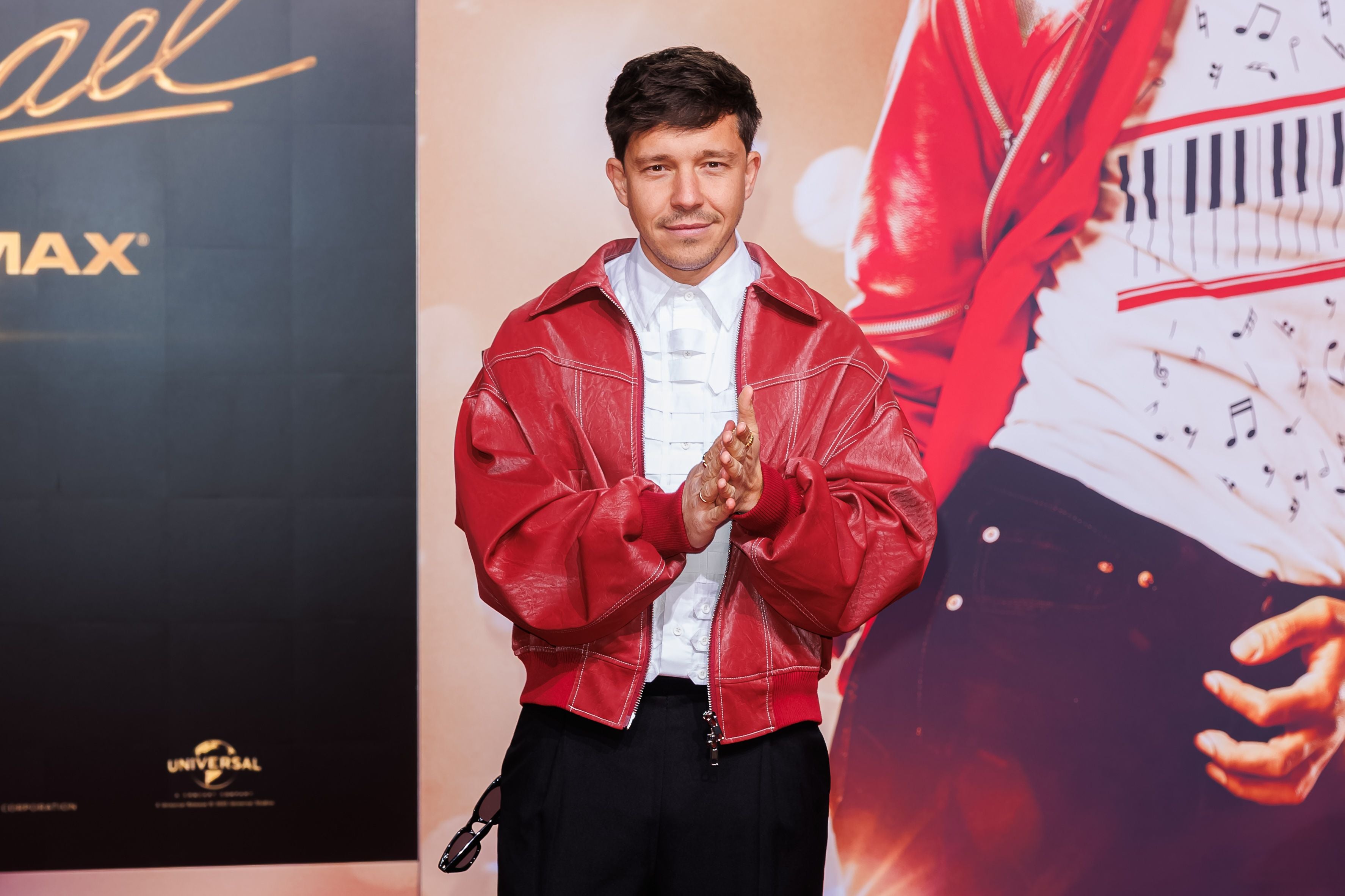Nico Santos in roter Jacke posiert auf dem roten Teppich bei einer Filmpremiere in Berlin.