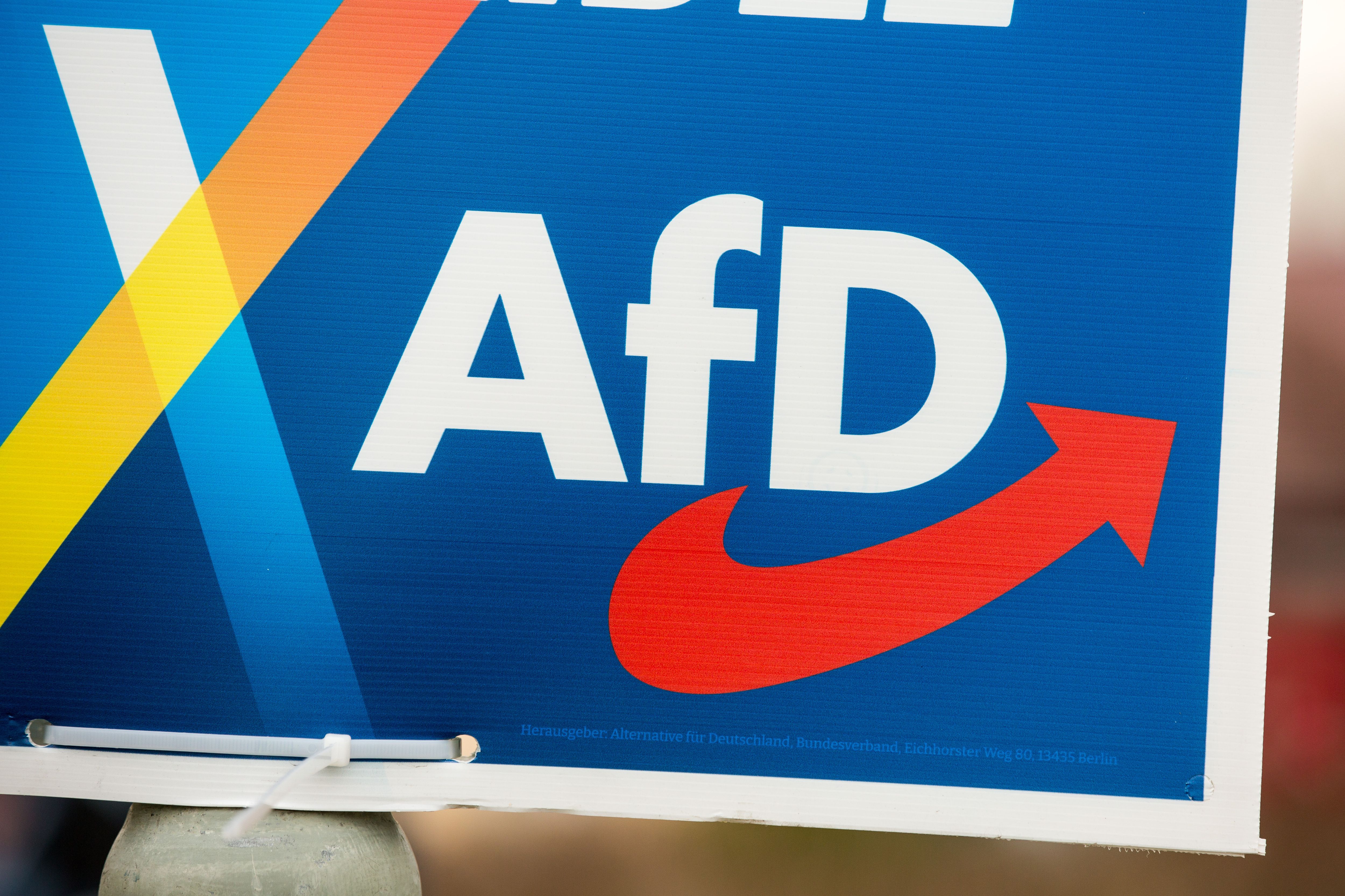 Wahlplakat der AfD mit großem weißen Schriftzug auf blauem Hintergrund und rotem Pfeil.