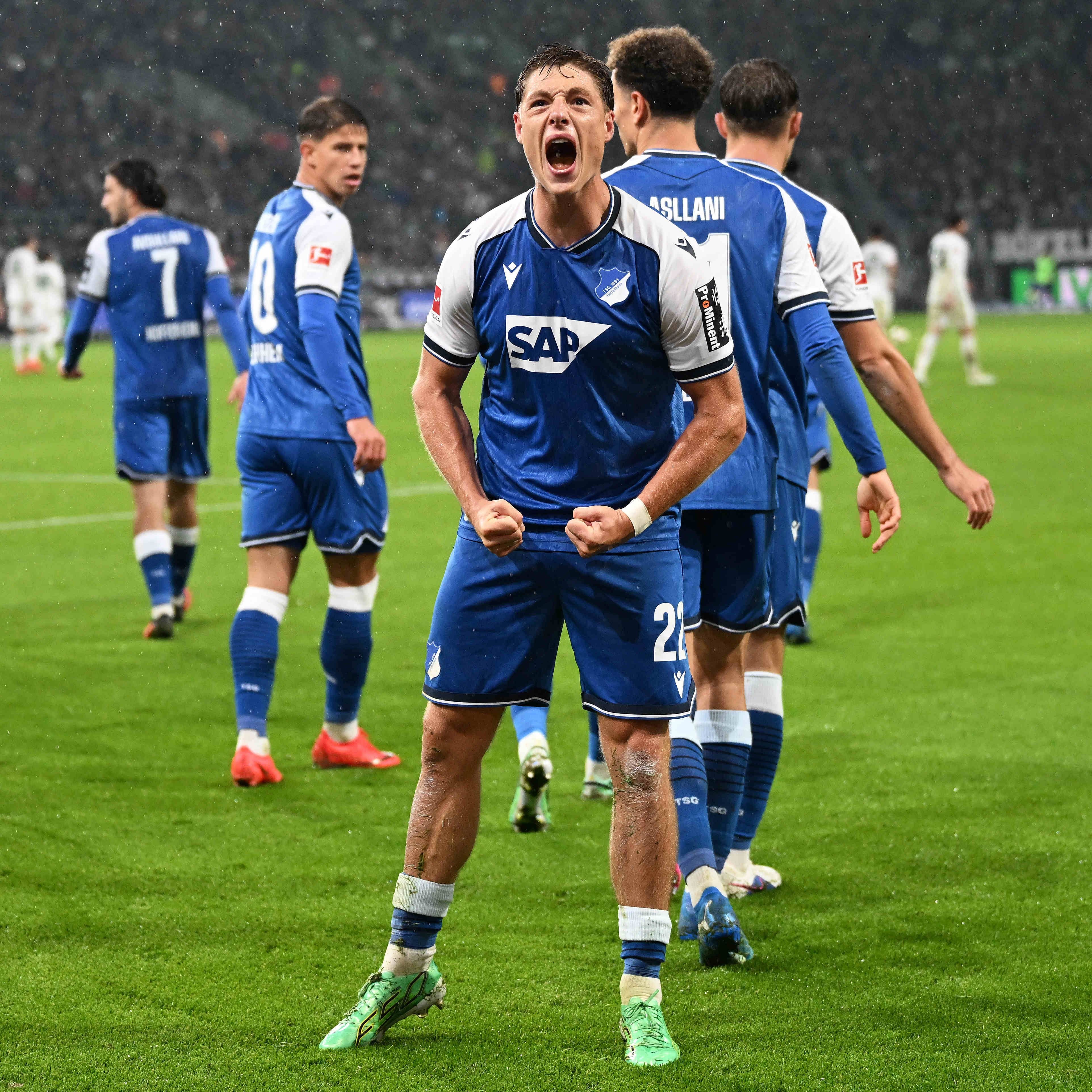 Ein Hoffenheim-Spieler jubelt mit geballten Fäusten nach einem Tor auf dem Fußballfeld.